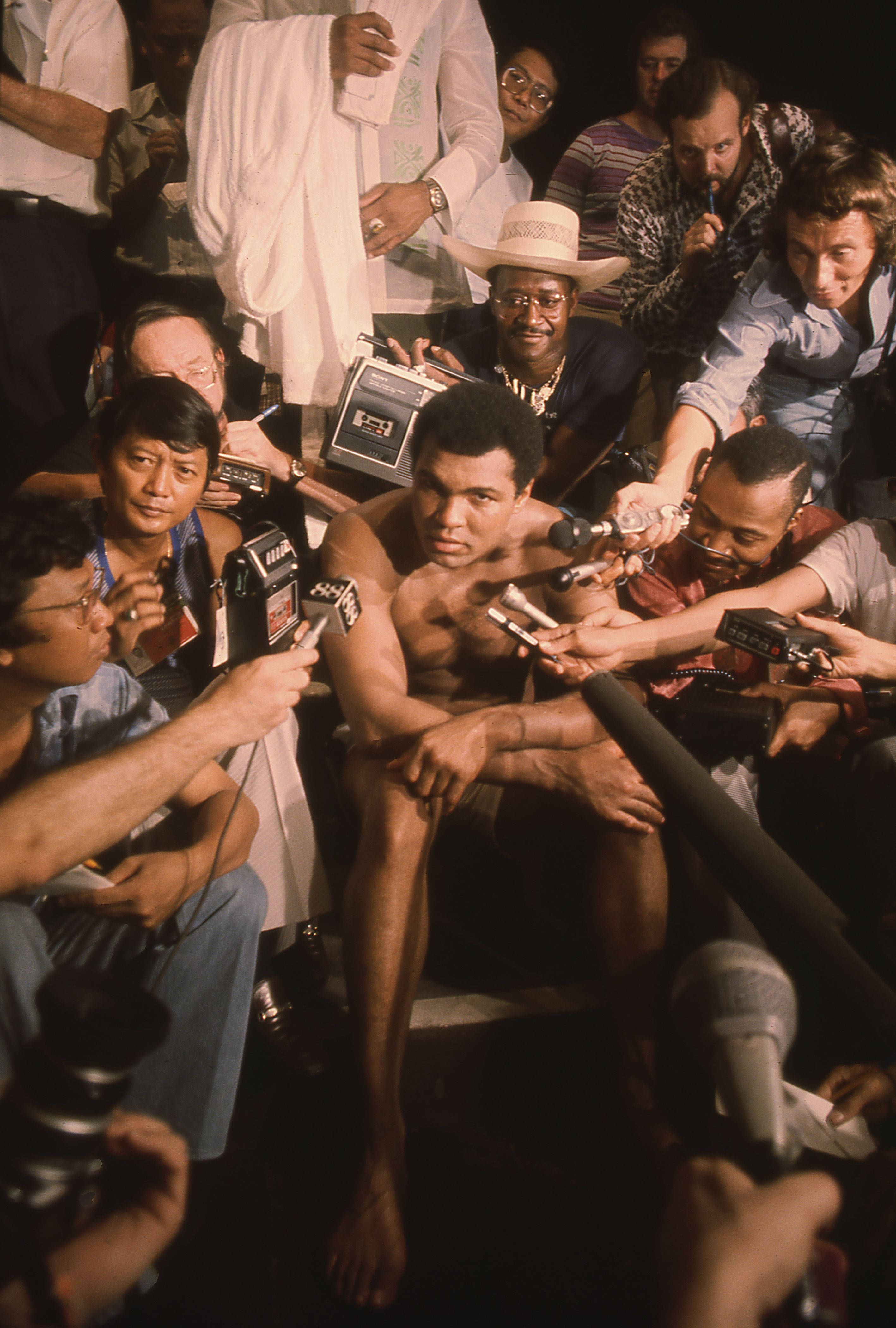 Picture of Muhammad Ali sitting among reporters