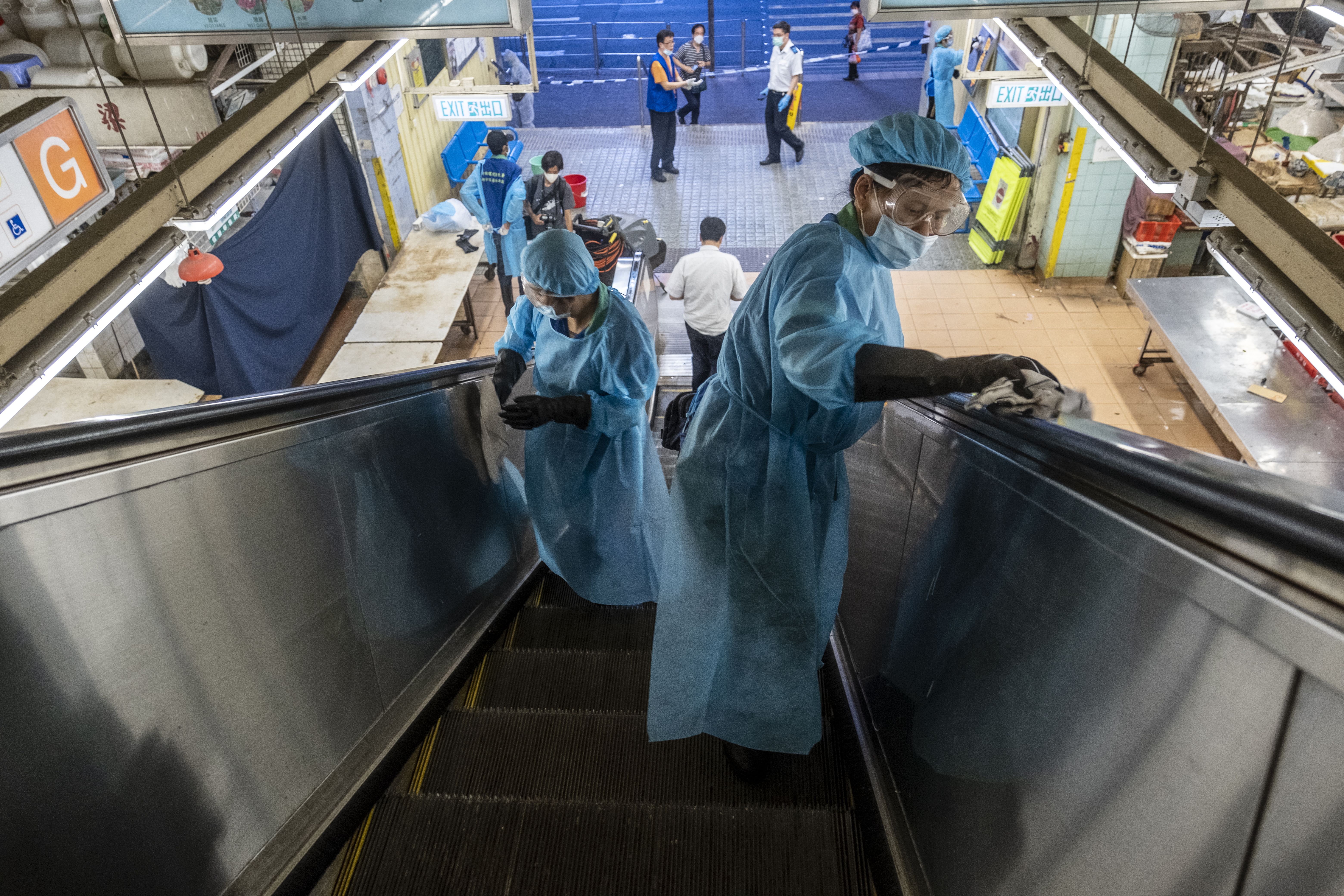 A Food and Environmental Hygiene Department contractor wearing personal protective equipment cleaning and disinfecting an escalator on July 19, 2020 in Hong Kong, China. Hong Kong