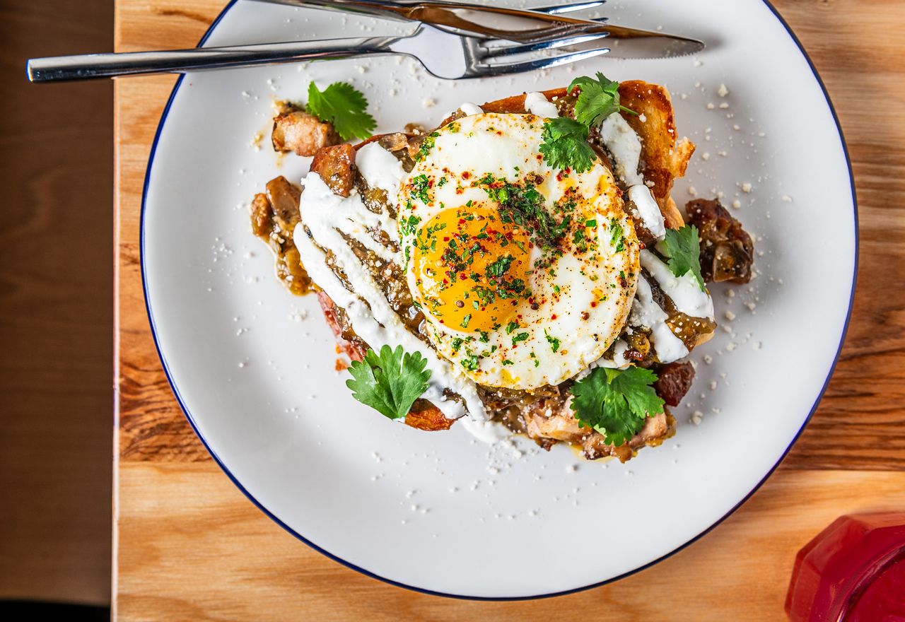 Toast topped with hatch green chili smothered pork belly and a runny egg with cilantro.