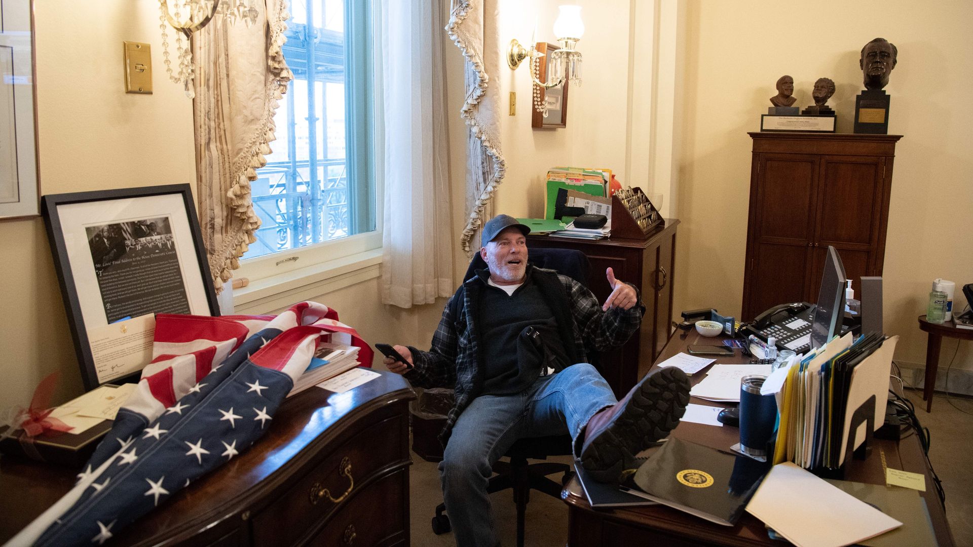 A pro-Trump supporter is seen sitting in the office of House Speaker Nancy Pelosi after overrunning the Capitol today.