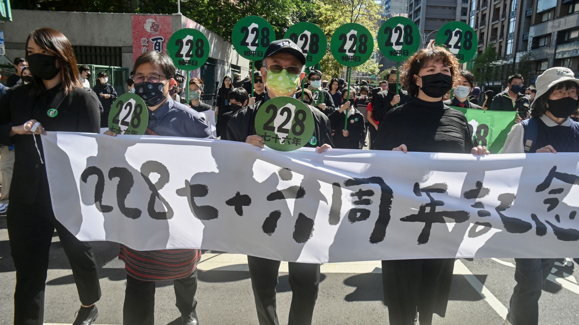 People display a banner to mark the 76th anniversary of the '228 incident' during a demonstration in Taipei on February 28, 2023.
