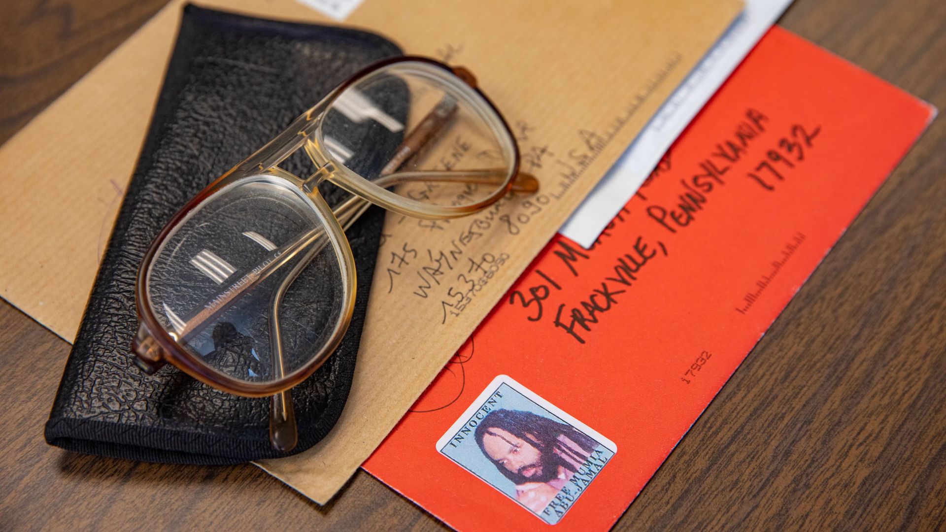 Mumia Abu-Jamal's longtime prescription glasses on top of letters he received from people across the globe.