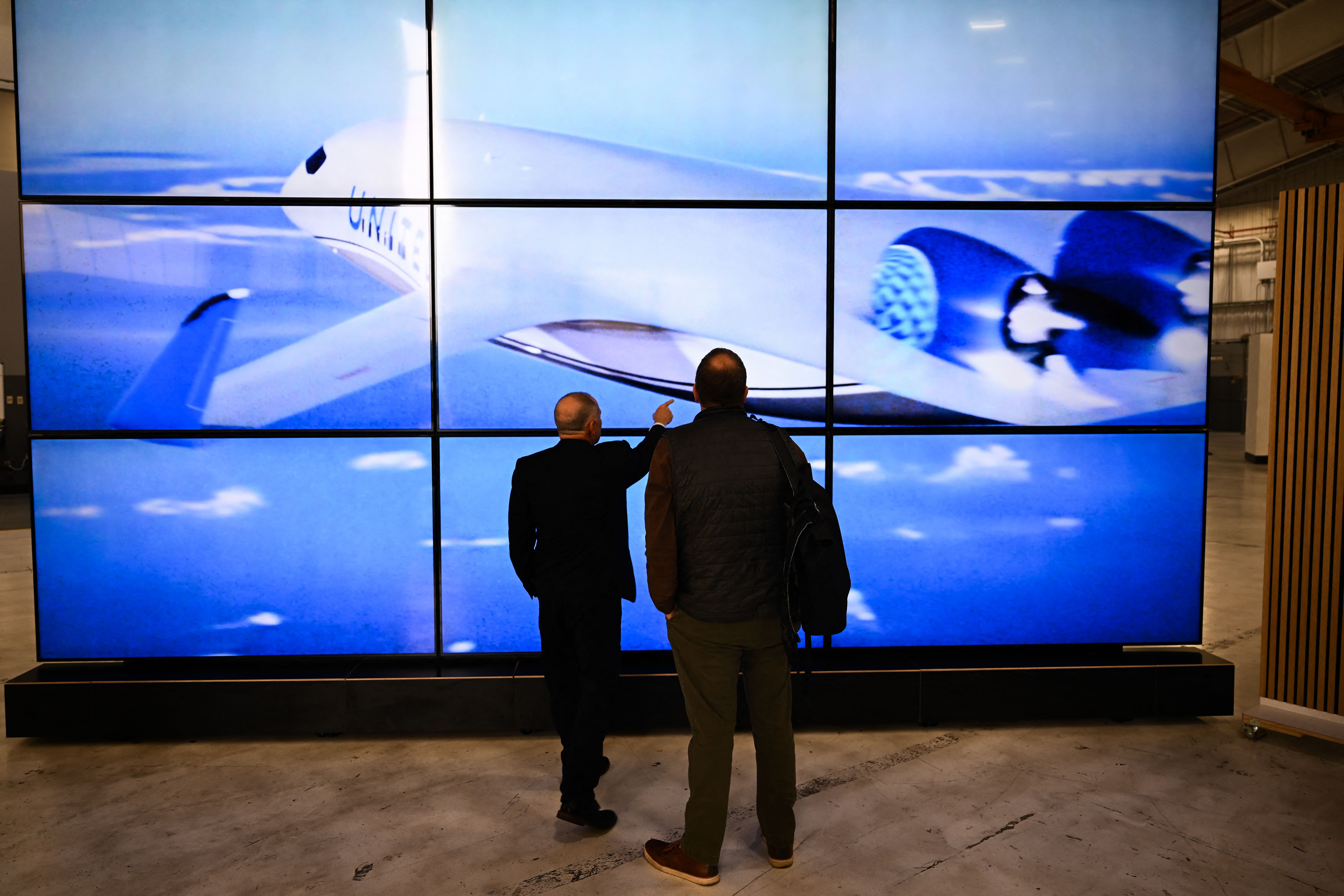 Attendees view a rendering of the JetZero Z4 blended wing body aircraft with United Airlines livery during the company's media day in Long Beach, California on May 2, 2025. JetZero is developing the world's first commercial all-wing design airplane. (Photo by Patrick T. Fallon / AFP) (Photo by PATRI