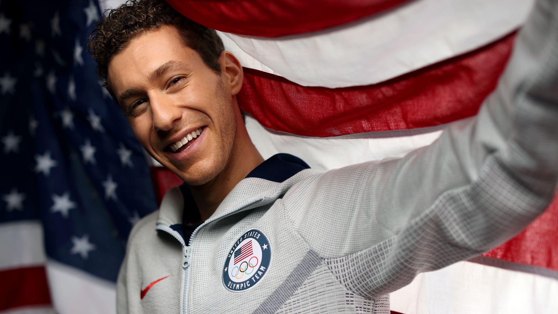 guy with an american flag behind him