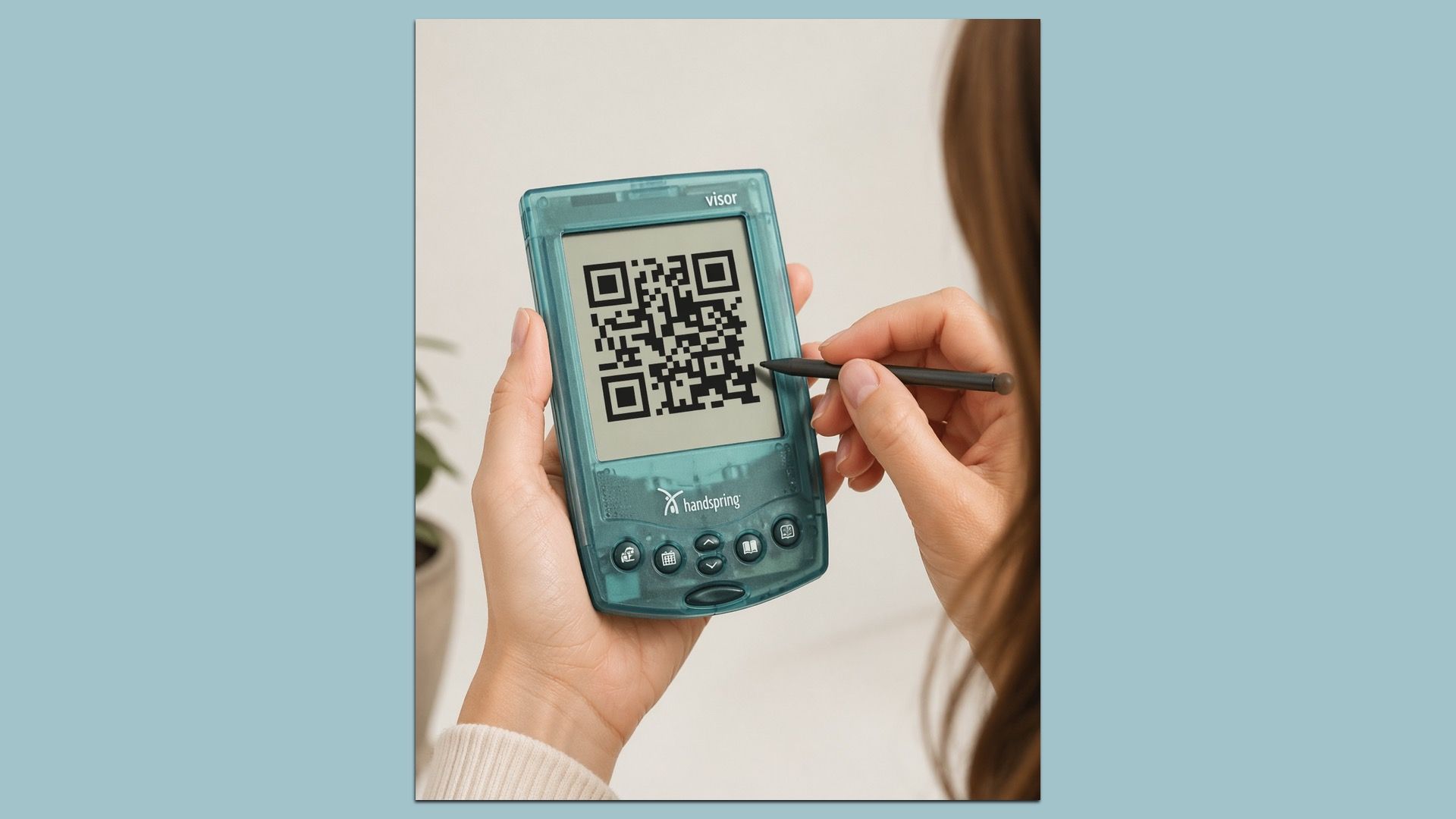 Teal handheld scanner showing a QR code, held by a person with a stylus touching the screen; visor at the top and handspring logo visible.