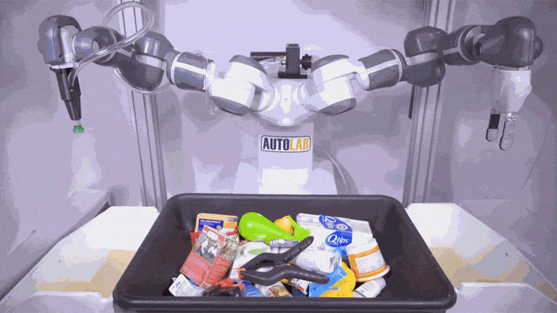 A video of a two-armed robot alternately picking up items from one bin and dropping them in another.