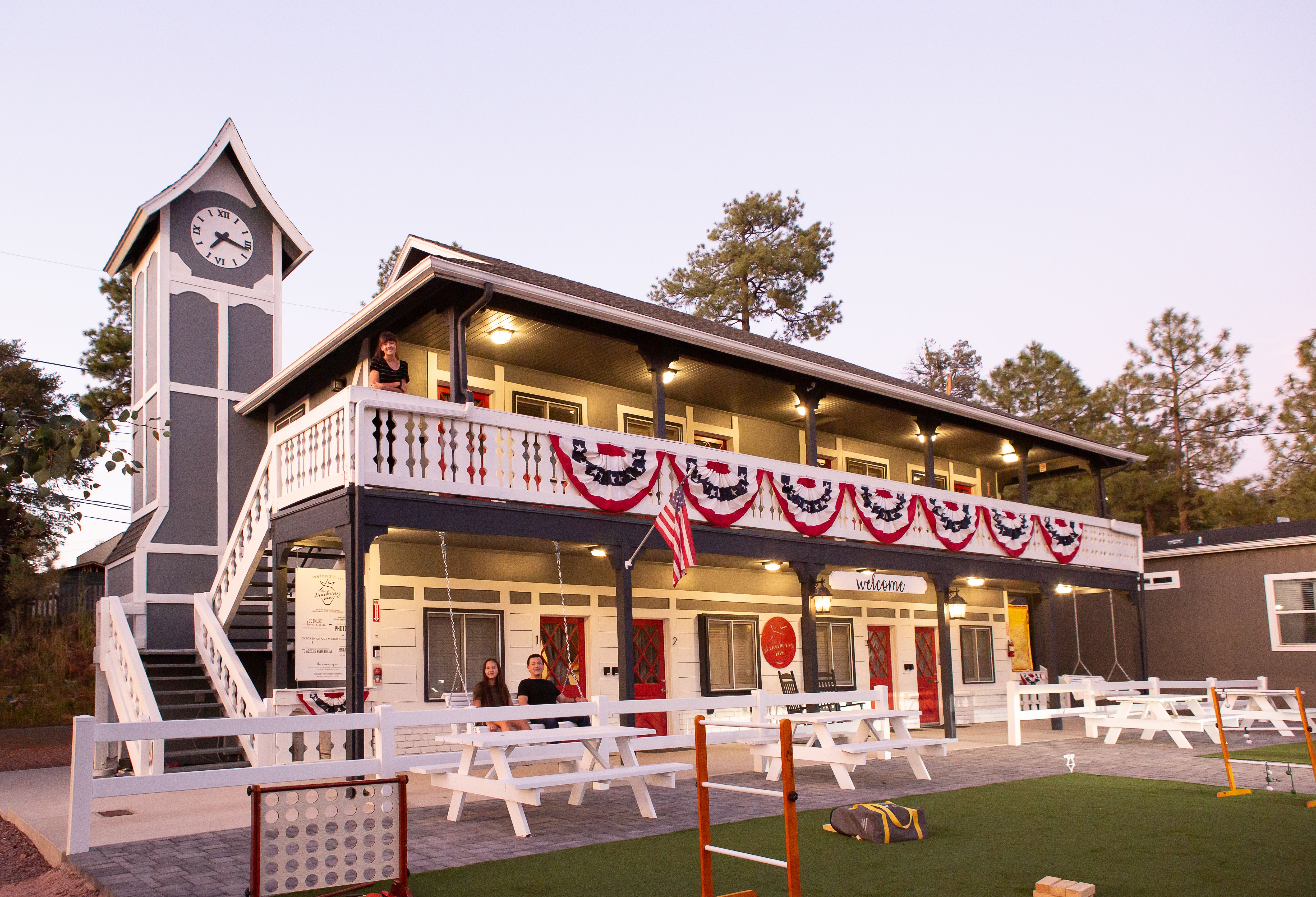 An inn with patriotic flags and picnic benches. 