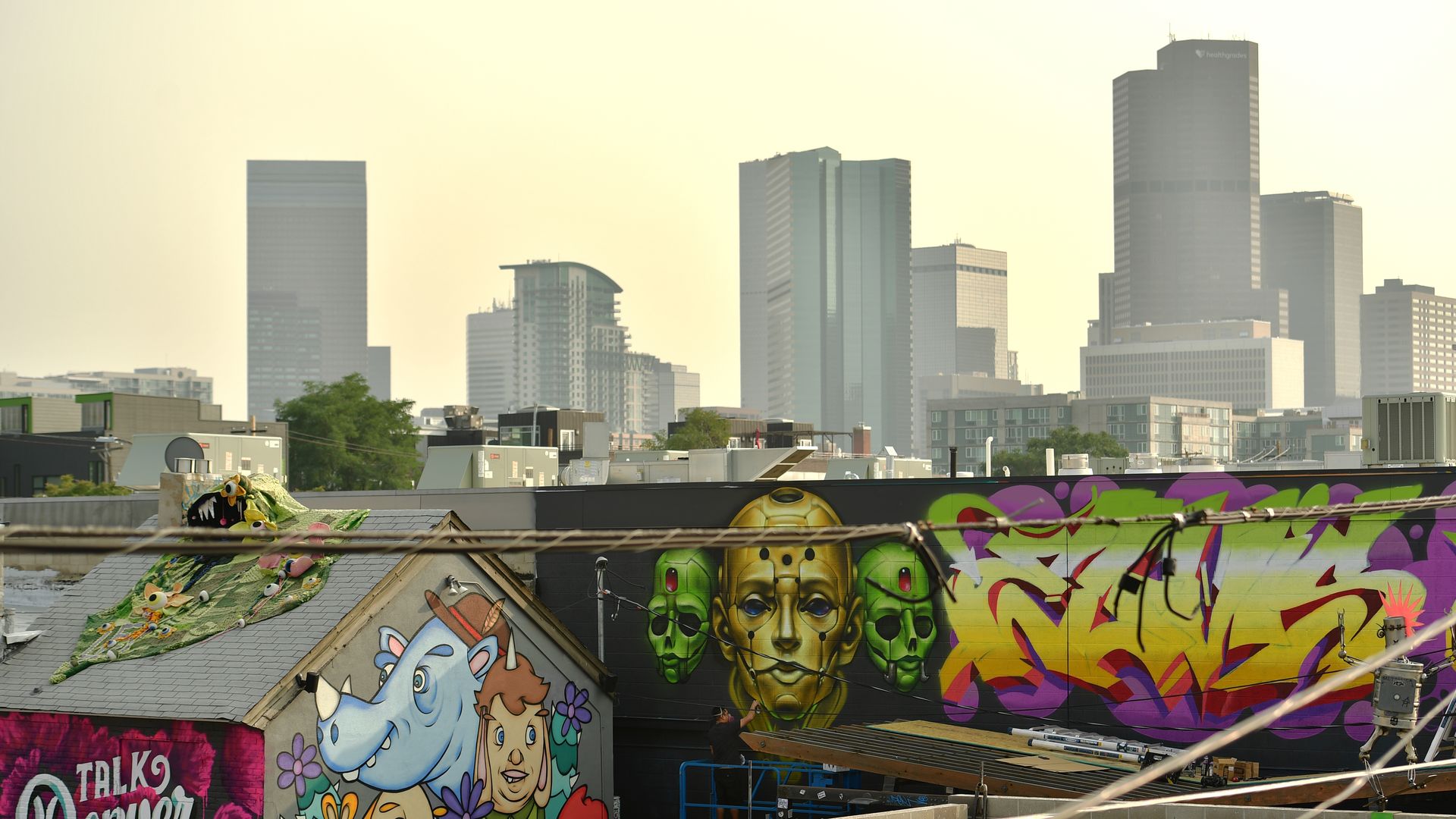 Two large structures with graffiti-style artwork, including faces and a blue cartoon rhino. 