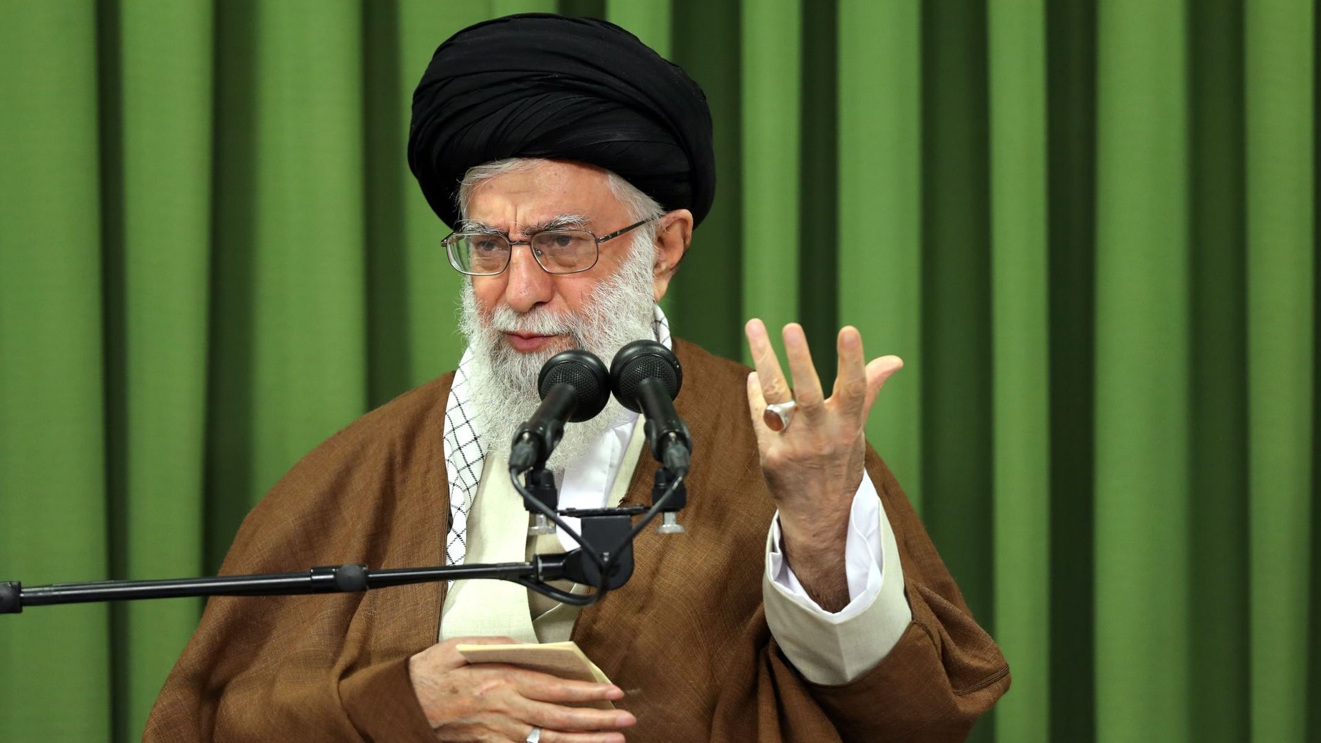 Ayatollah Khameini speaking while seated on stage