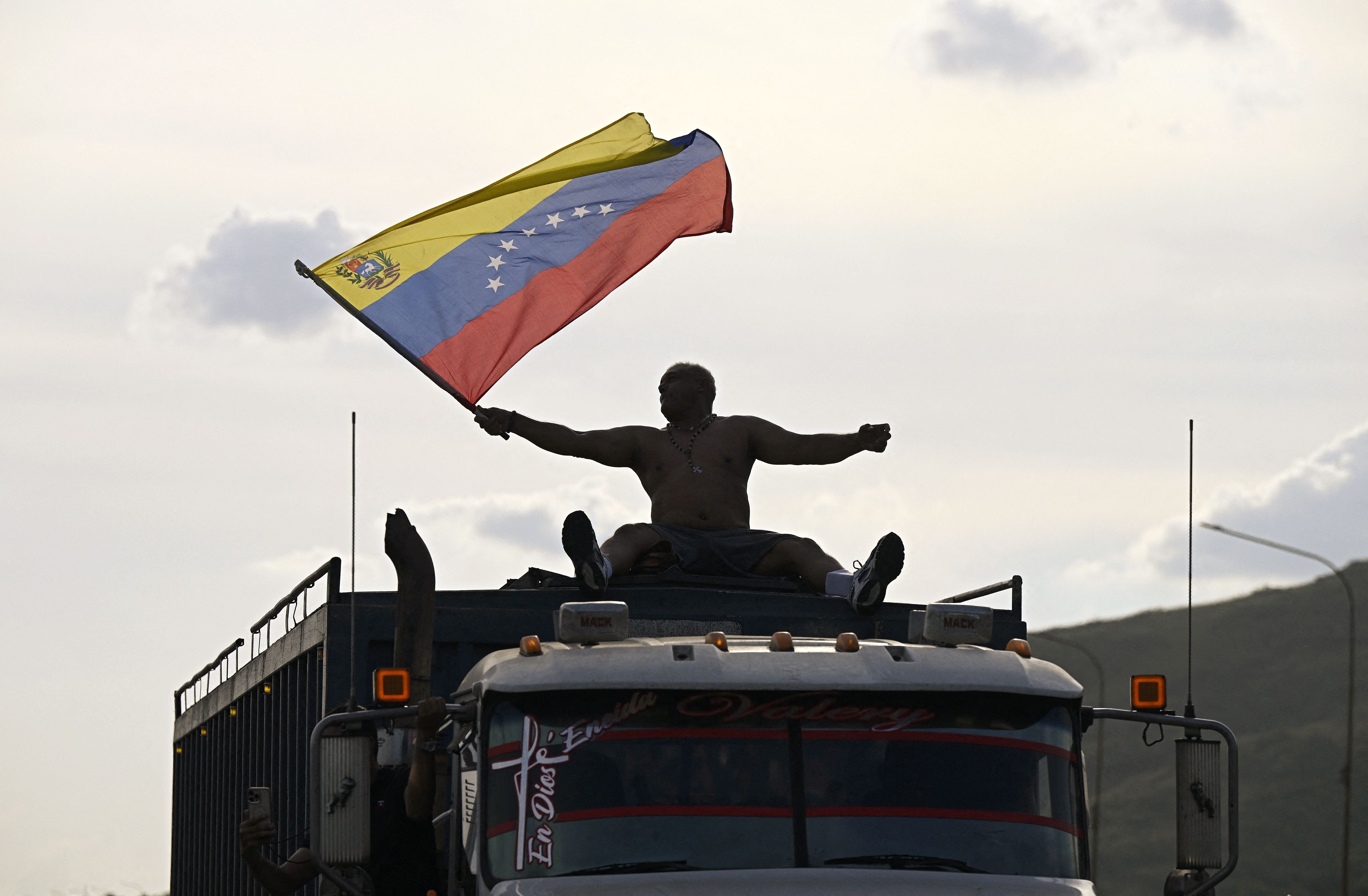 A supporter of opposition leader Maria Corina Machado waves a Venezuelan flag on top of a truck after her arrival in Caracas on Sunday. 