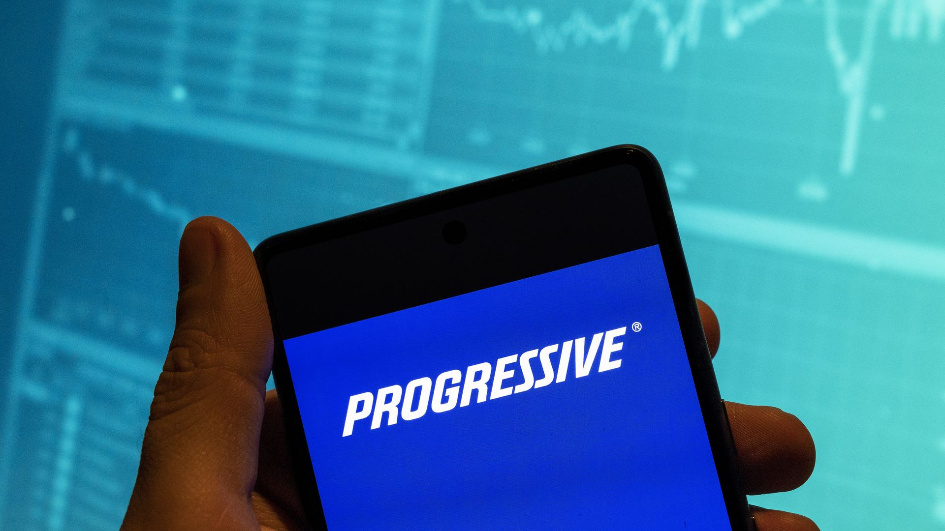 Hand holding a phone with Progressive app open 