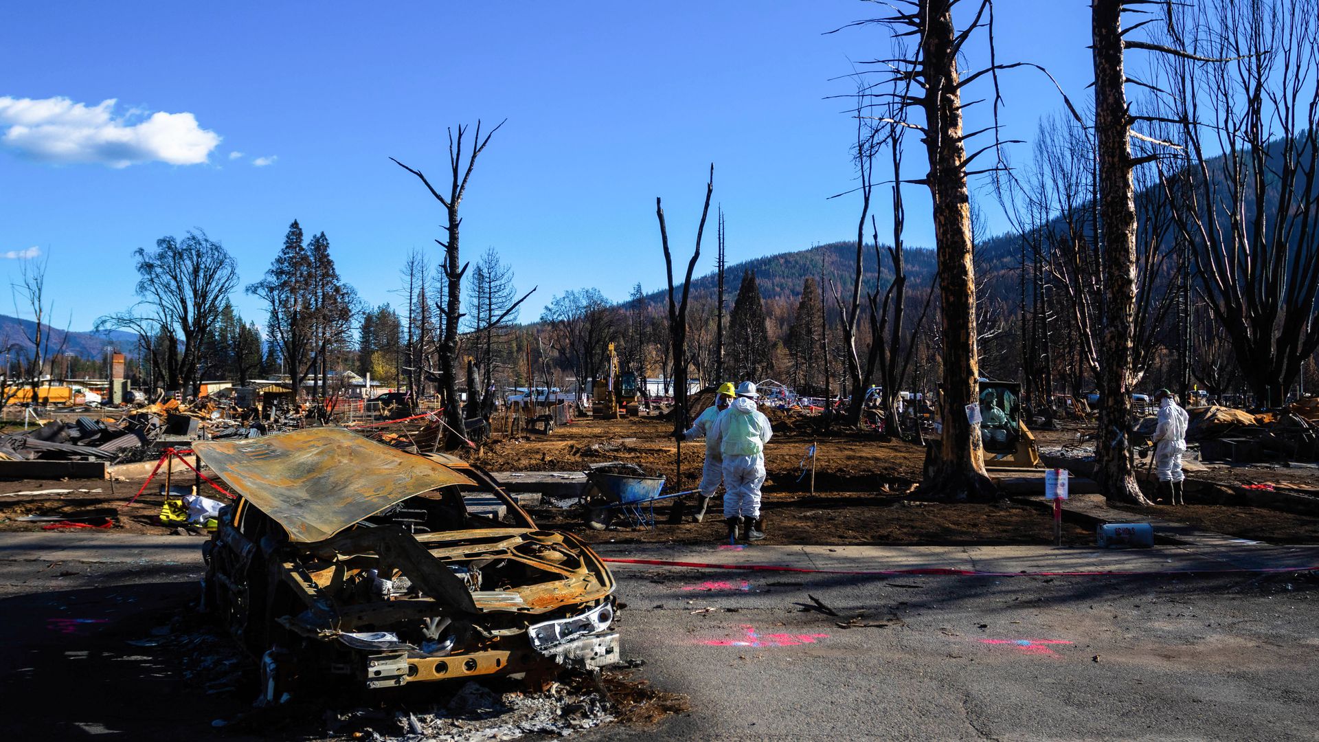 Crews work among burned materials from the Dixie fire. 