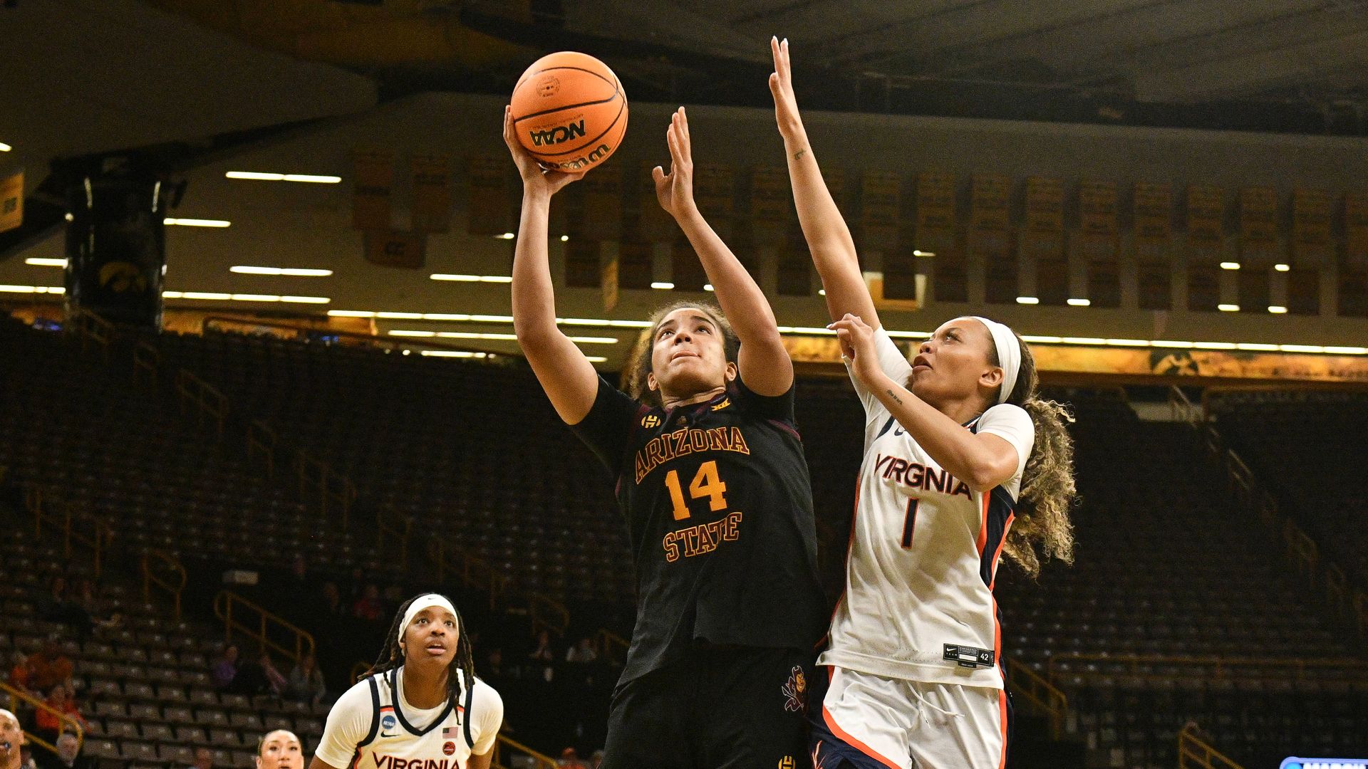 An ASU women's basketball player goes up for a layup against a Virginia defender.