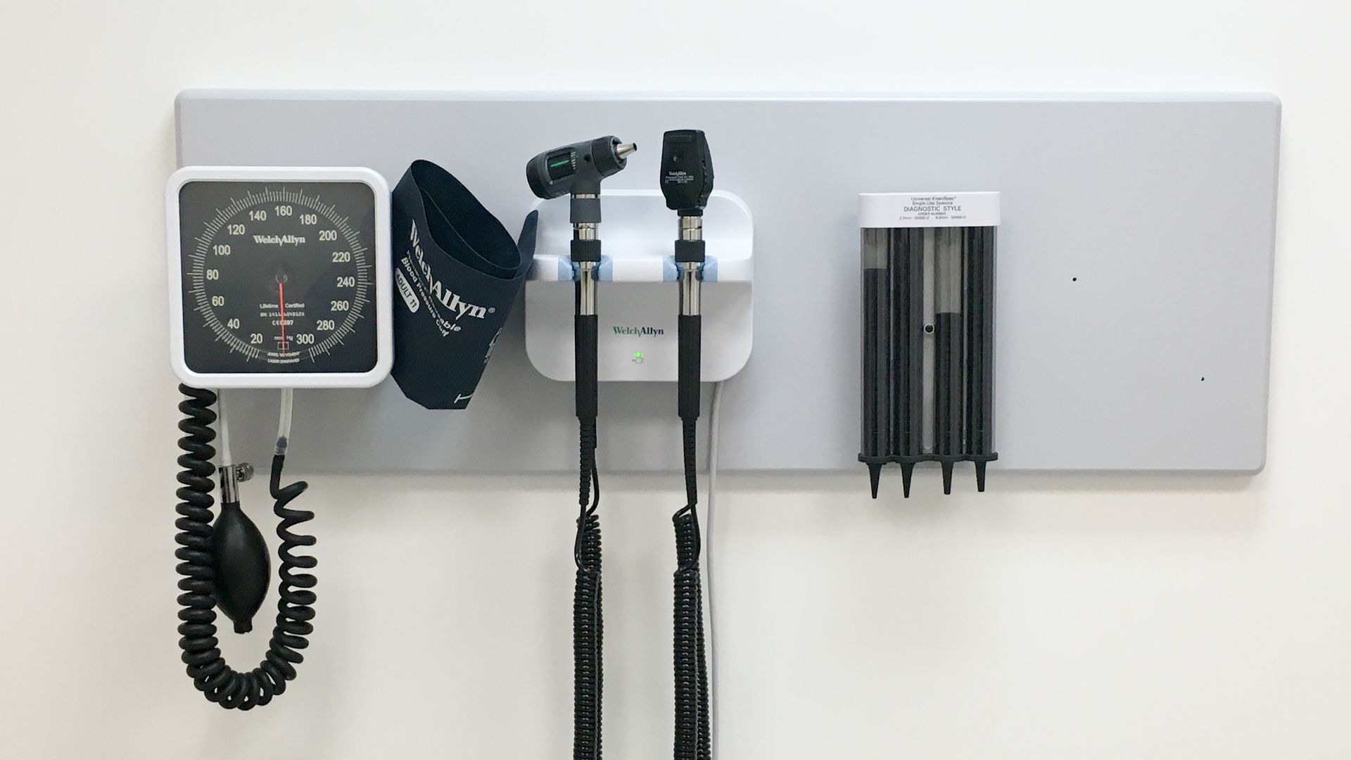 Tools on the wall of a doctor's office, including monitor to measure blood pressure