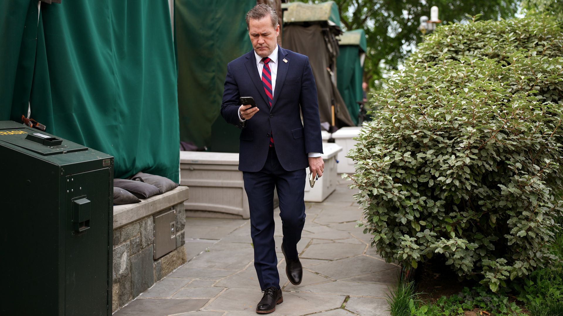 : National Security Advisor Michael Waltz looks at his phone as he prepares for a TV interview at the White House on May 01, 2025 in Washington, DC. This week marks the first 100 days of U.S. President Donald Trump's second term. (Photo by Andrew Harnik/Getty Images)