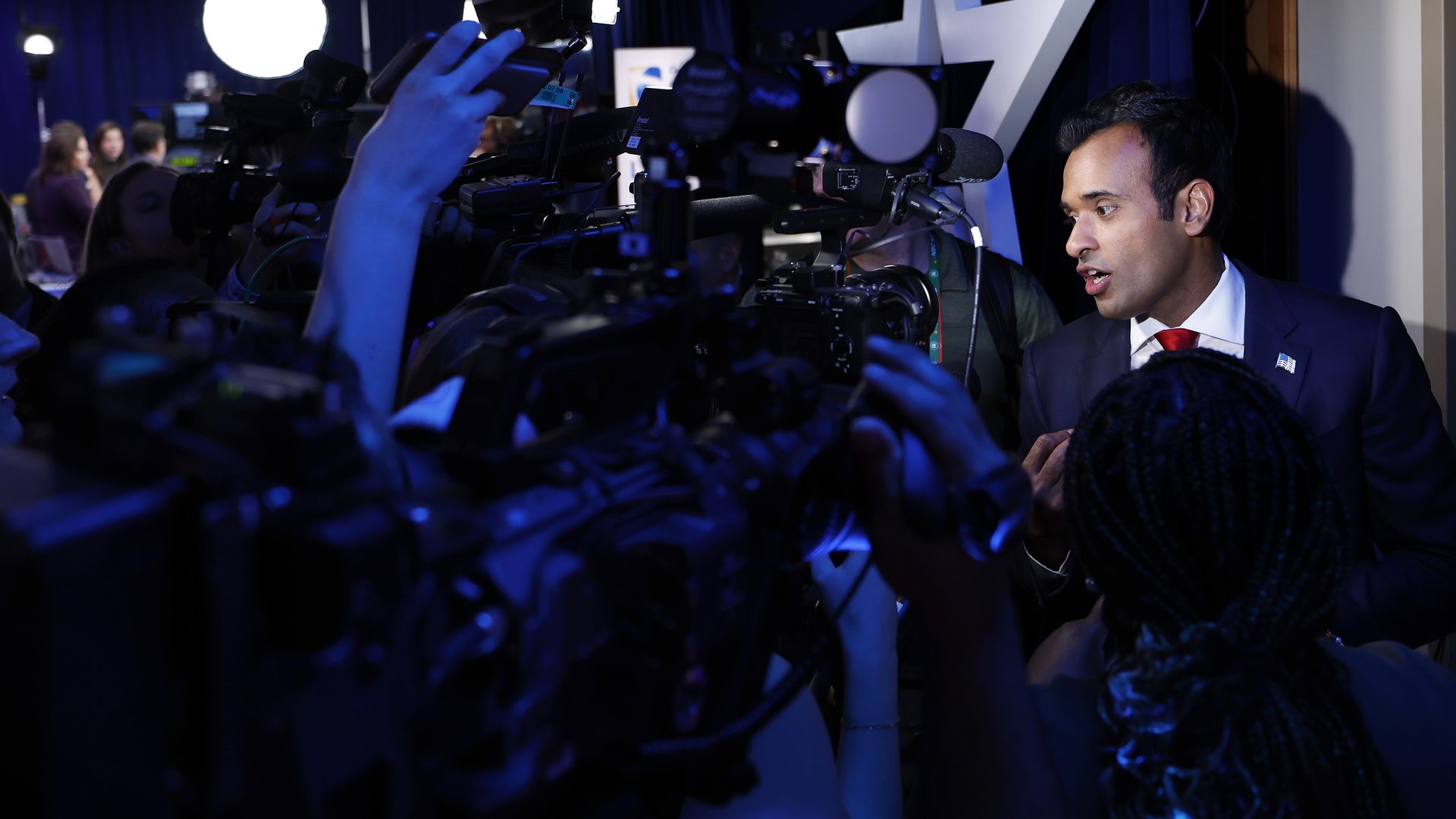A political candidate in a scrum of reporters following an event. 
