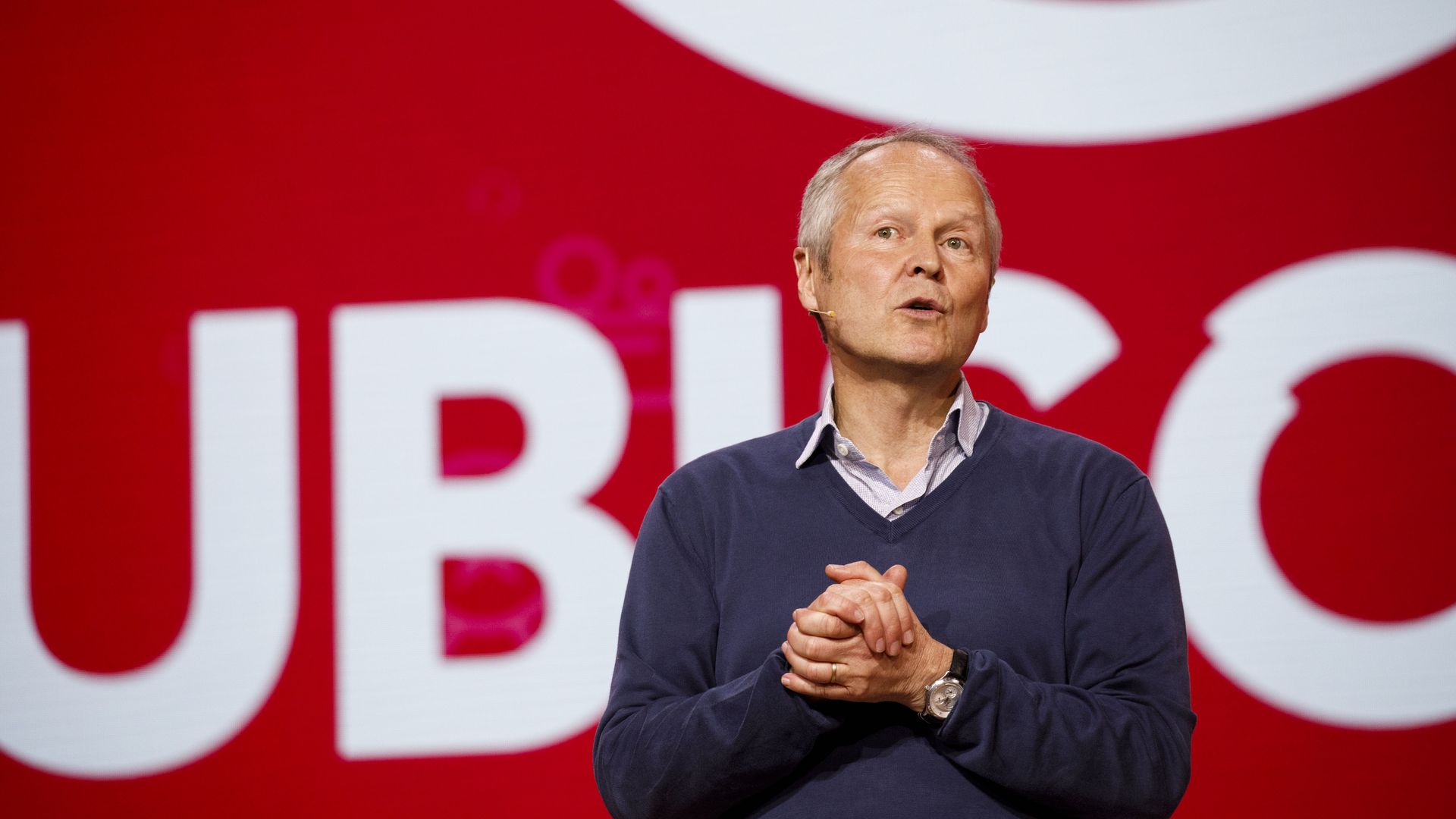 Ubisoft CEO Yves Guillemot stands in front of the company's logo