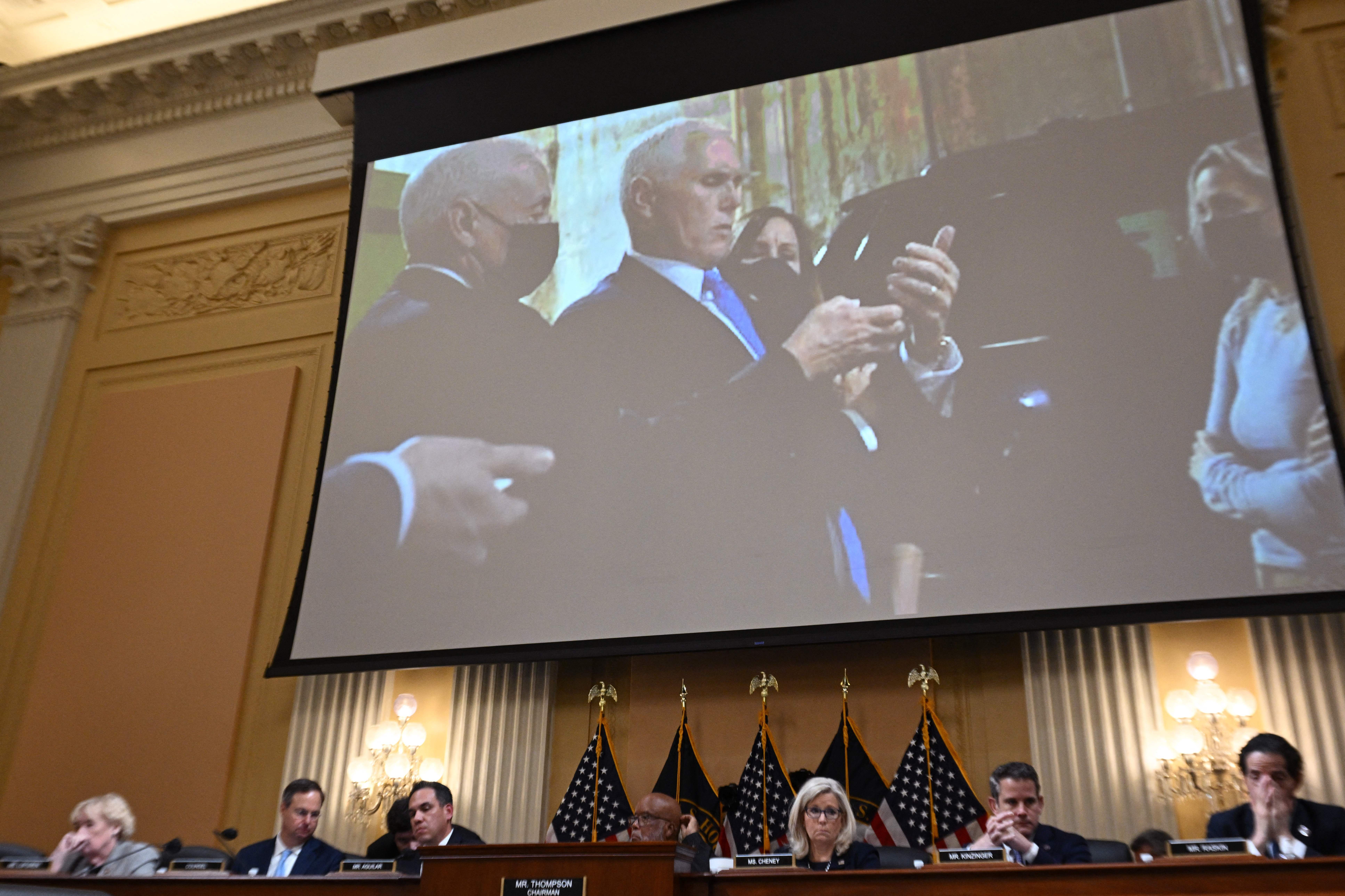 An image on a screen shows former US Vice President Mike Pence looking at his phone as he shelters on Jan. 6.
