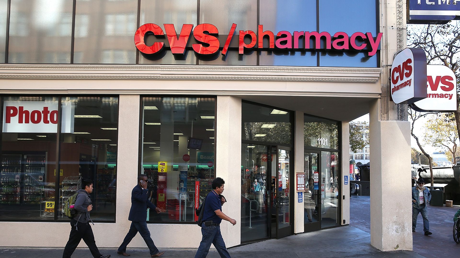 People walk outside a CVS pharmacy store.