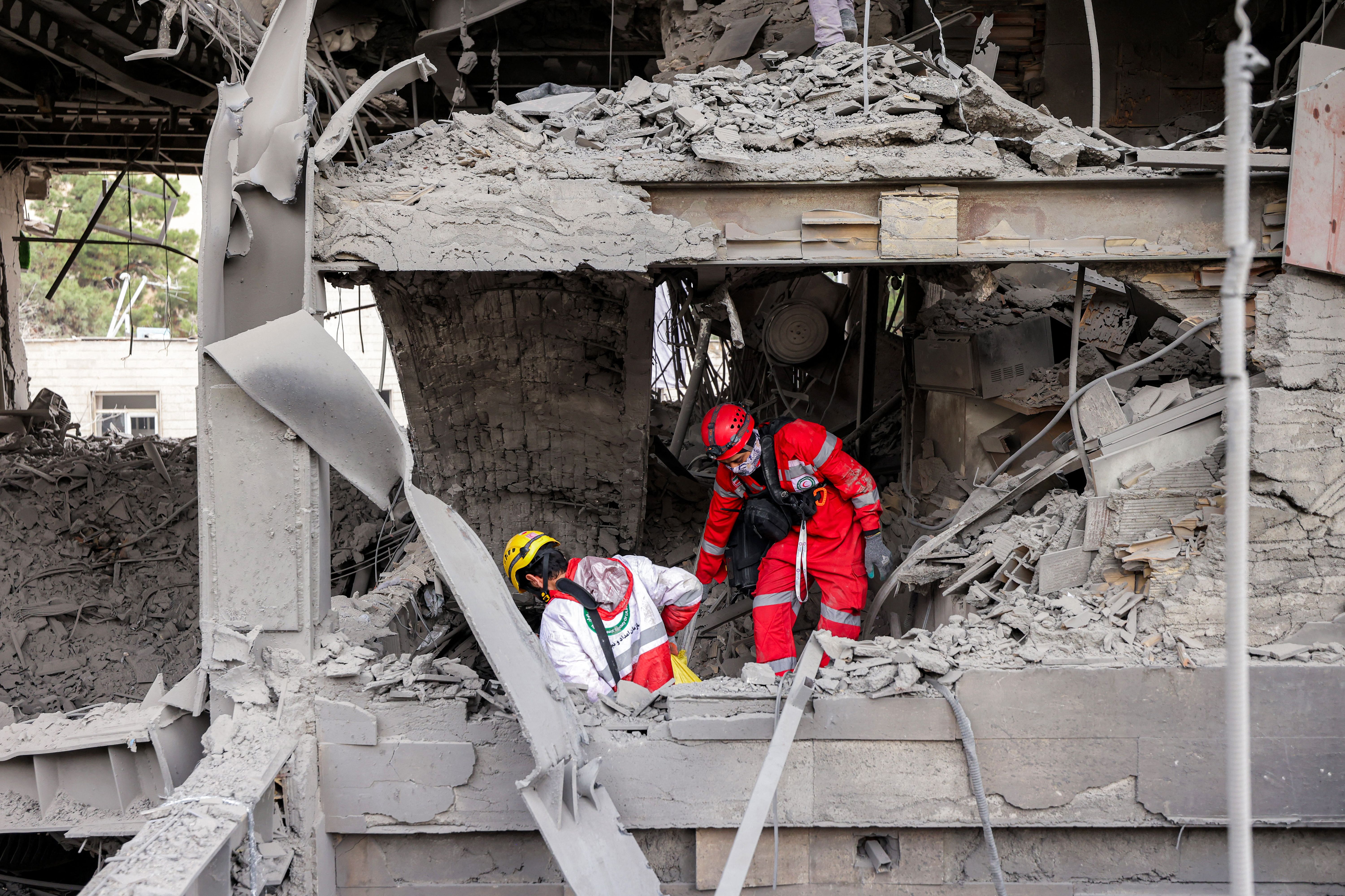 First responders search an office building in Tehran that housed the offices of the Doha-headquartered news network Al Araby TV after a missile strike yesterday.