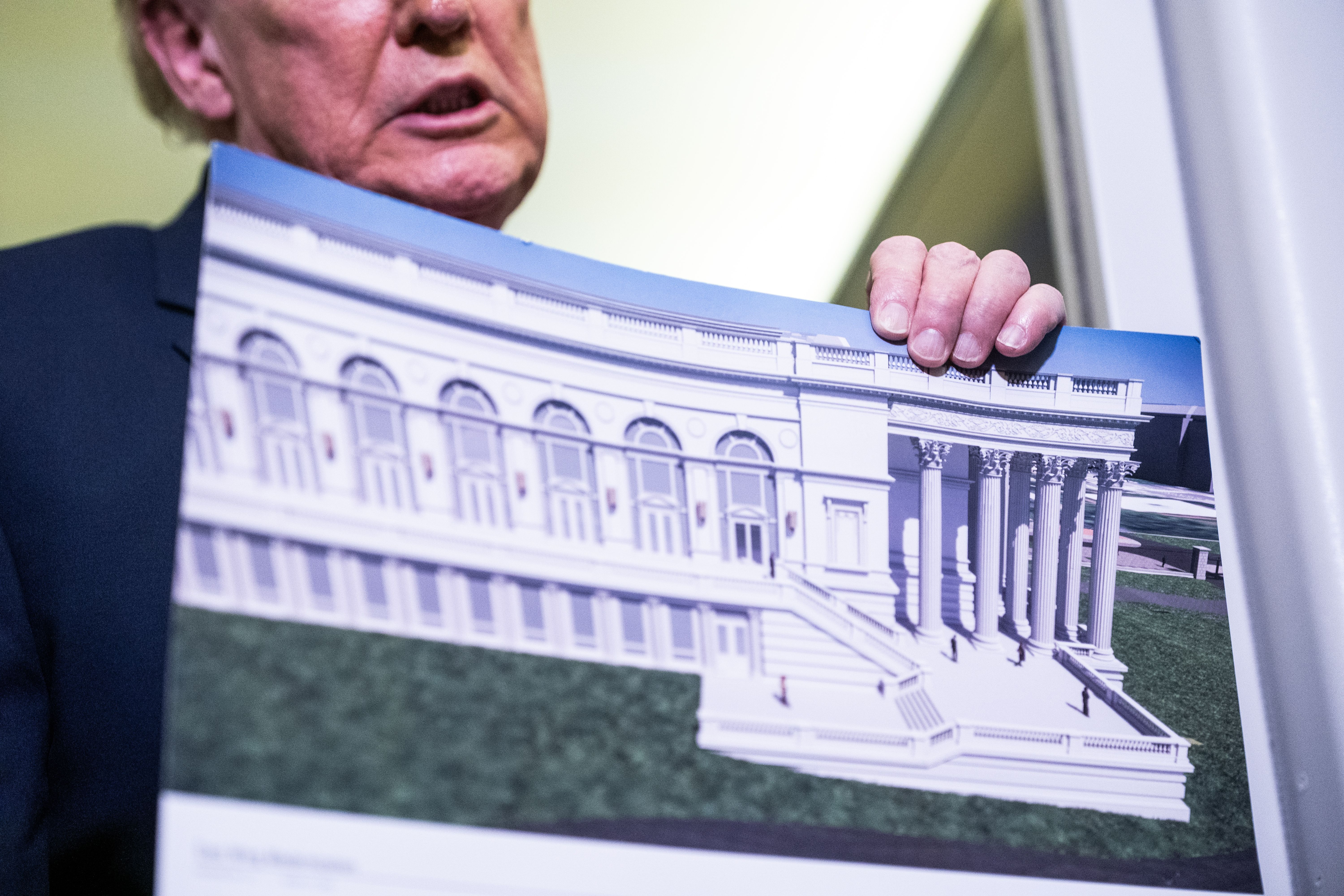 IN FLIGHT - MARCH 29: U.S. President Donald Trump holds a rendering of the proposed East Wing of the White House while speaking to members of the media onboard Air Force One on March 29, 2026 while en route to Joint Base Andrews, Maryland from West Palm Beach Florida. President Trump returned to Was