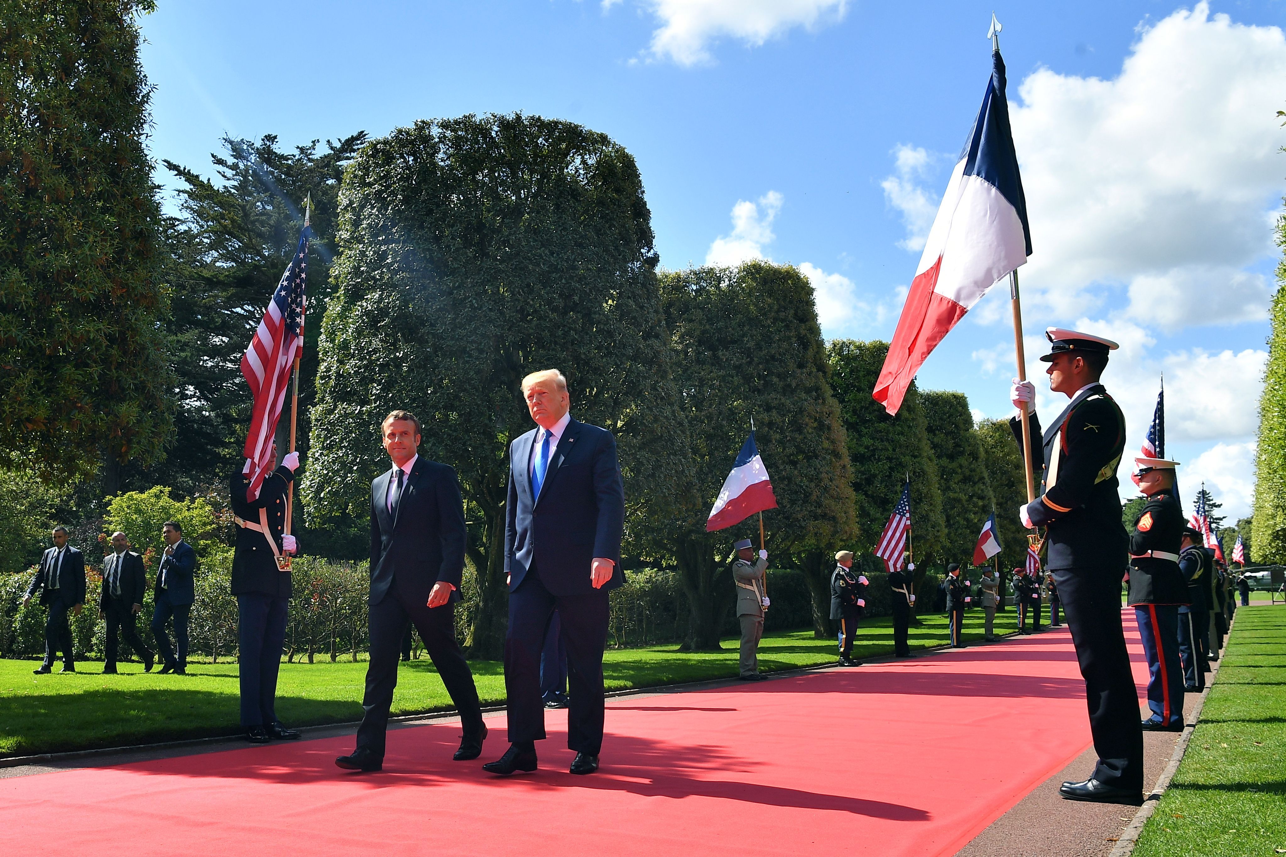 French President Emmanuel Macron (L) and US President Donald Trump walk on the red carpet.