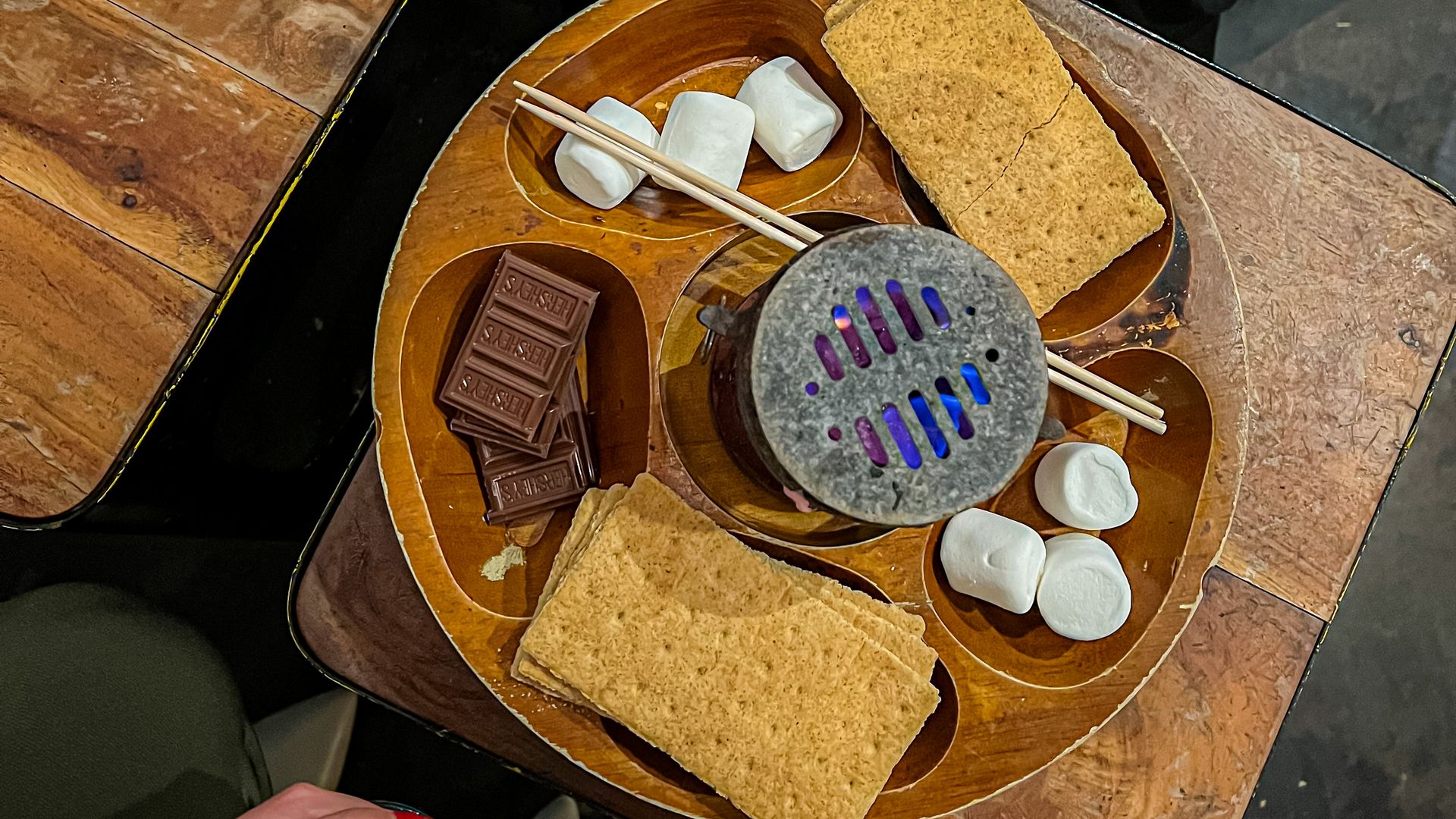 A table top s'mores set up with graham crackers, marshmallows and chocolates. 