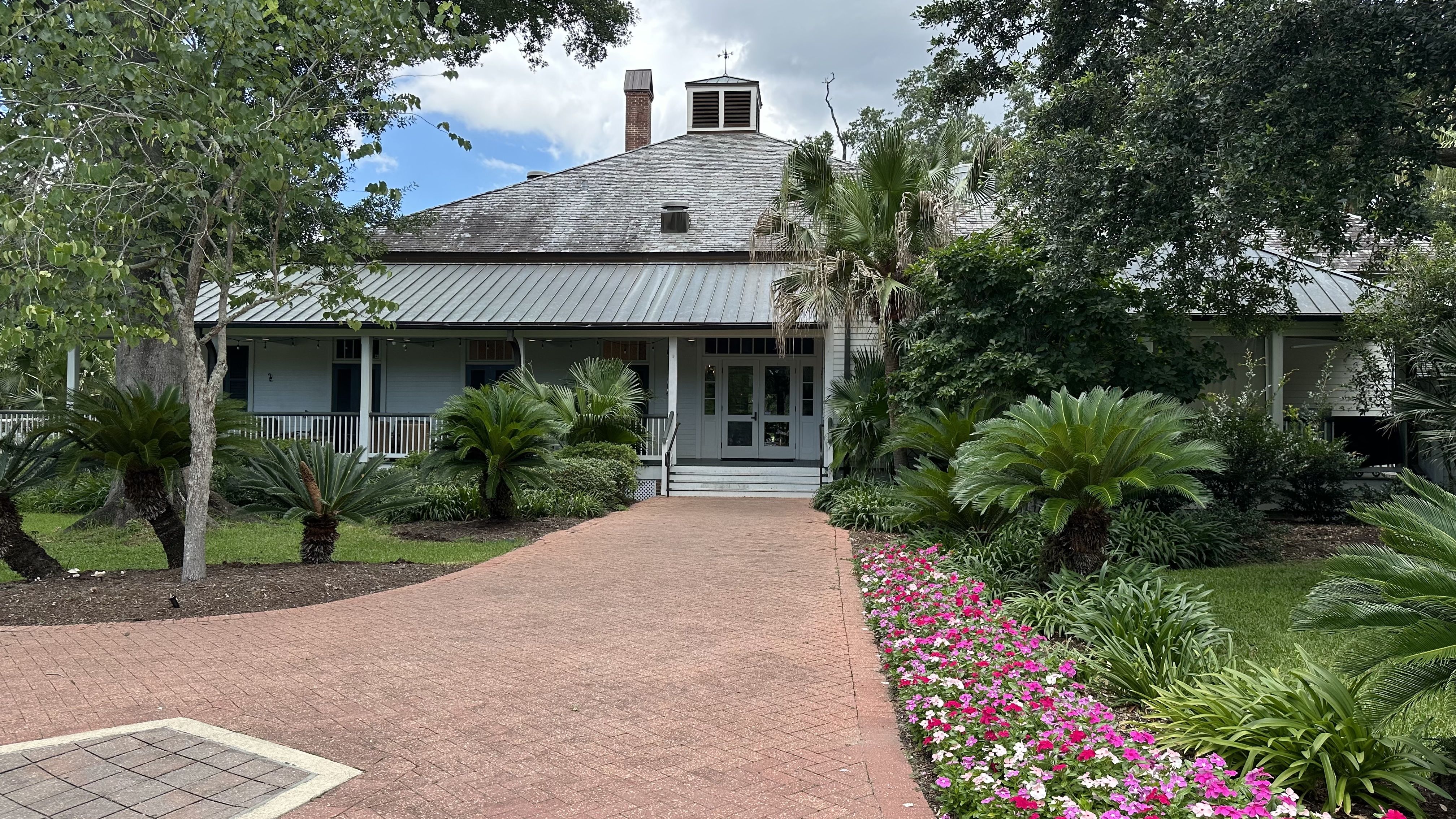 Photo of a large residential-style building with a brick walkway heading toward it.
