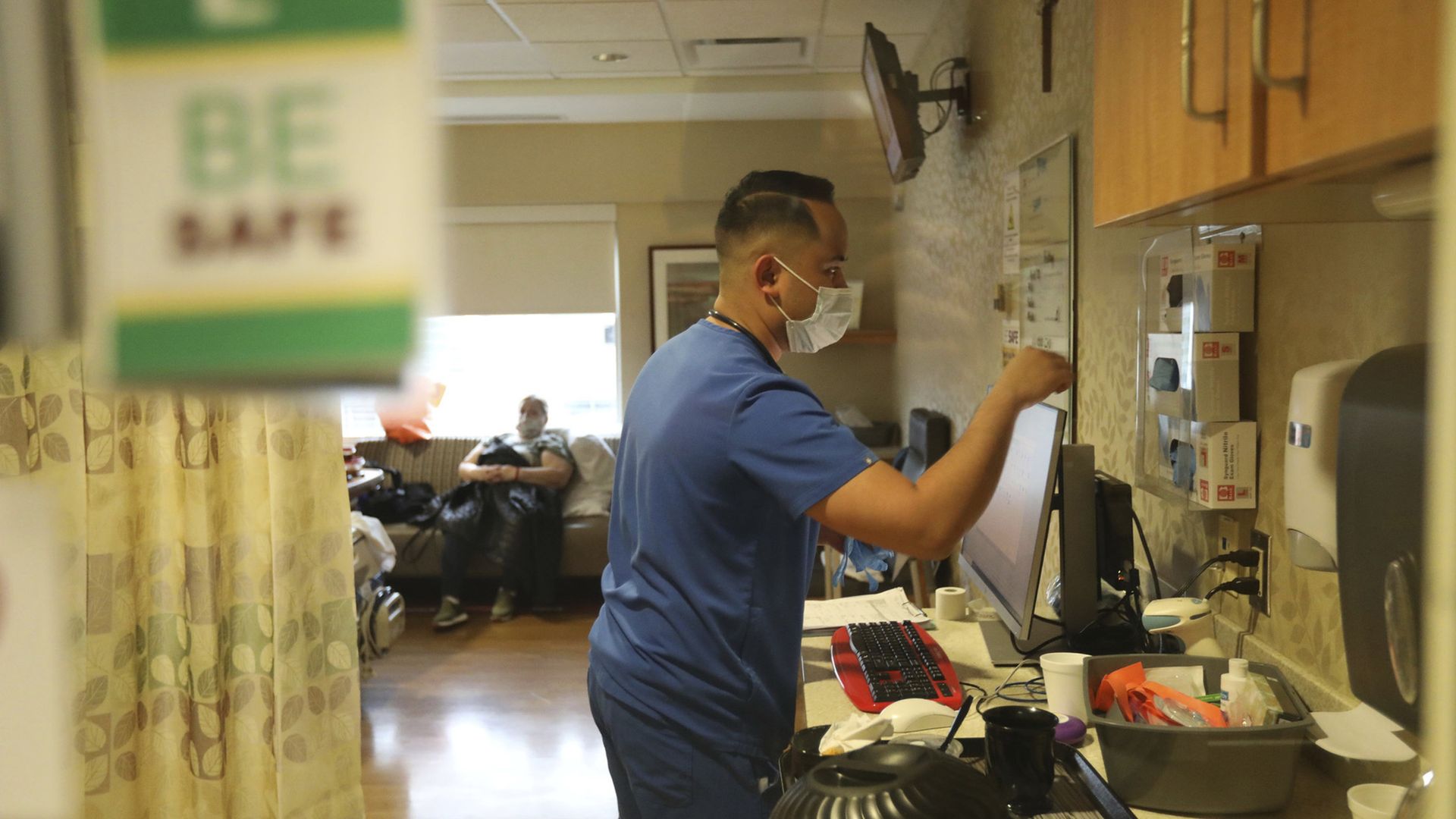 Registered nurse Paolo Salvallon wears his face mask as he checks in on a patient at Loyola University Medical Center in Maywood, Illinois, Friday, April 22, 2022
