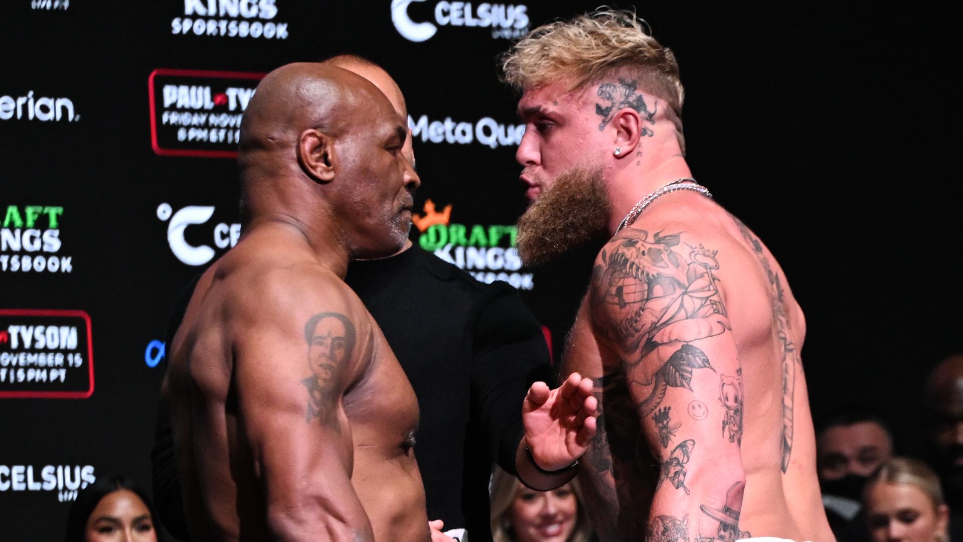 Two boxers without their shirts on face off on a stage