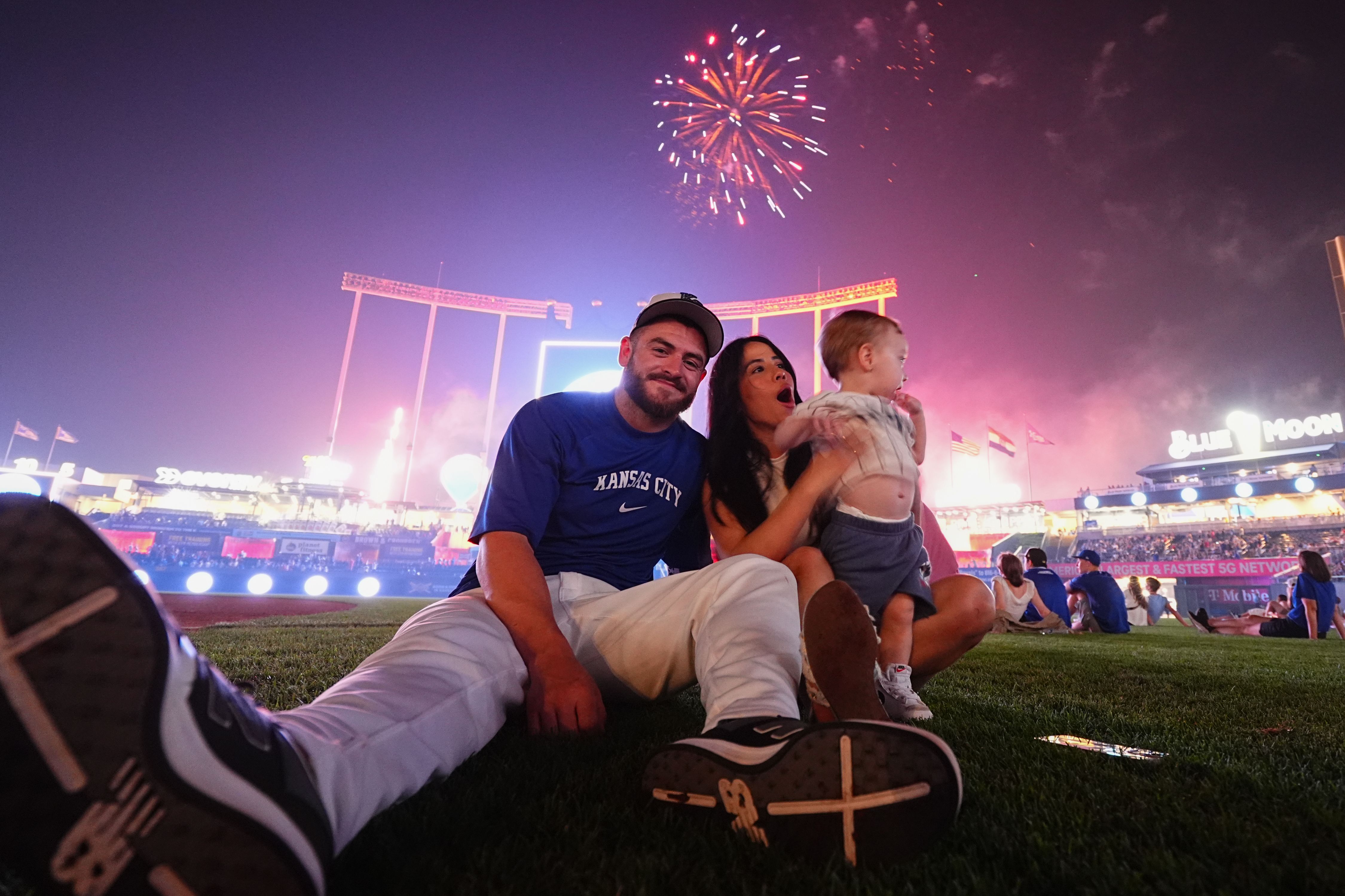 Kyle Isbel #28 of the Kansas City Royals and family members pose for a photo as the Fireworks spectacular show goes on after the Tampa Bay Rays defeated the Kansas City Royals at Kauffman Stadium on July 4, 2024 in Kansas City, Missouri. 