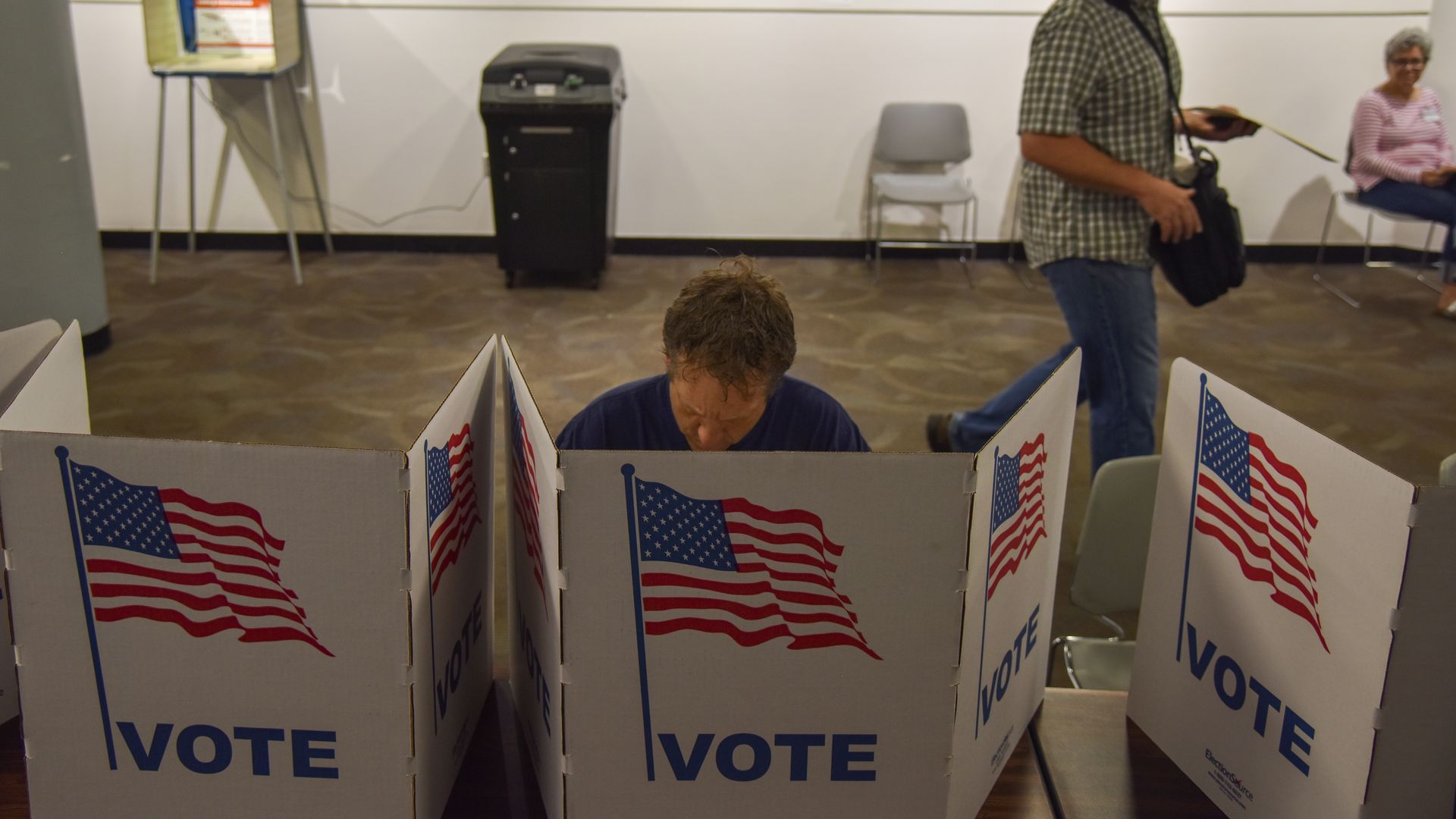 A person voting at the ballot box.