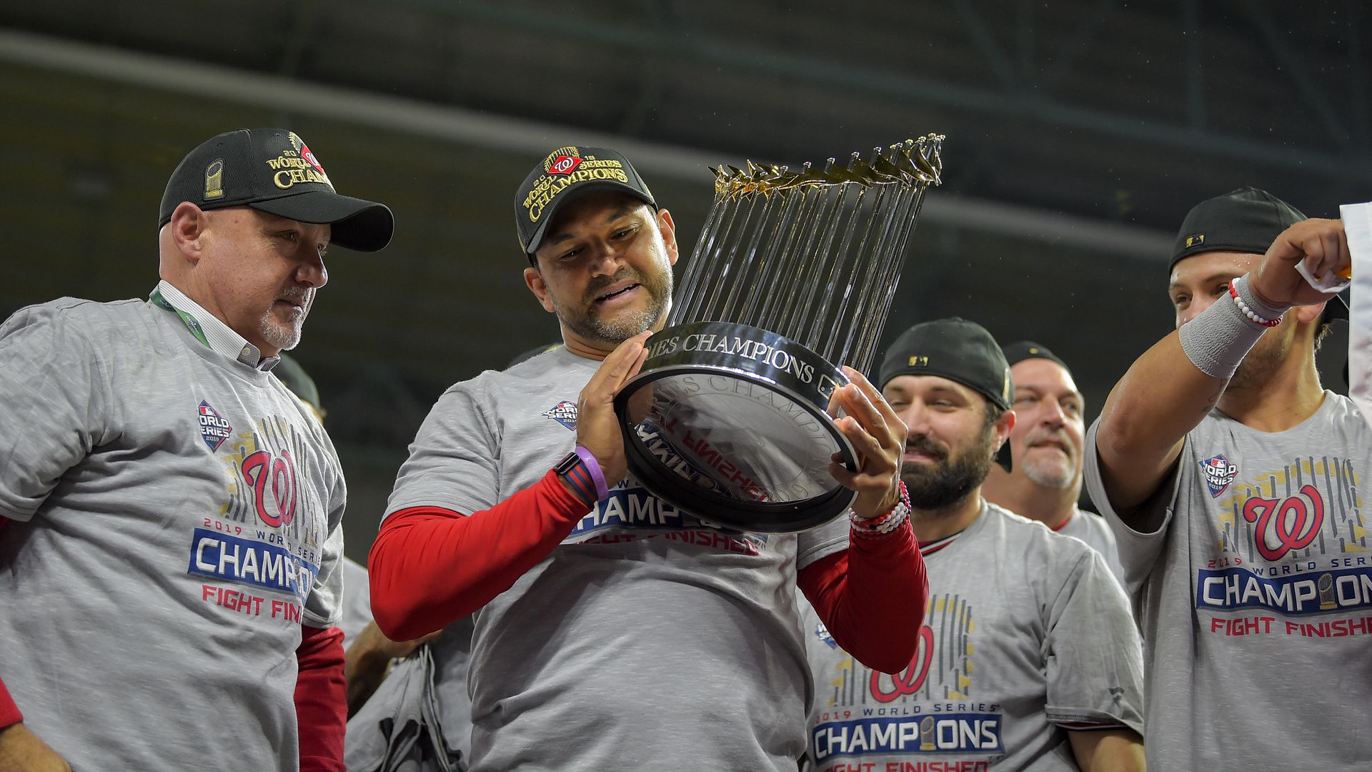 Members of the Washington Nationals hold their championship trophy.