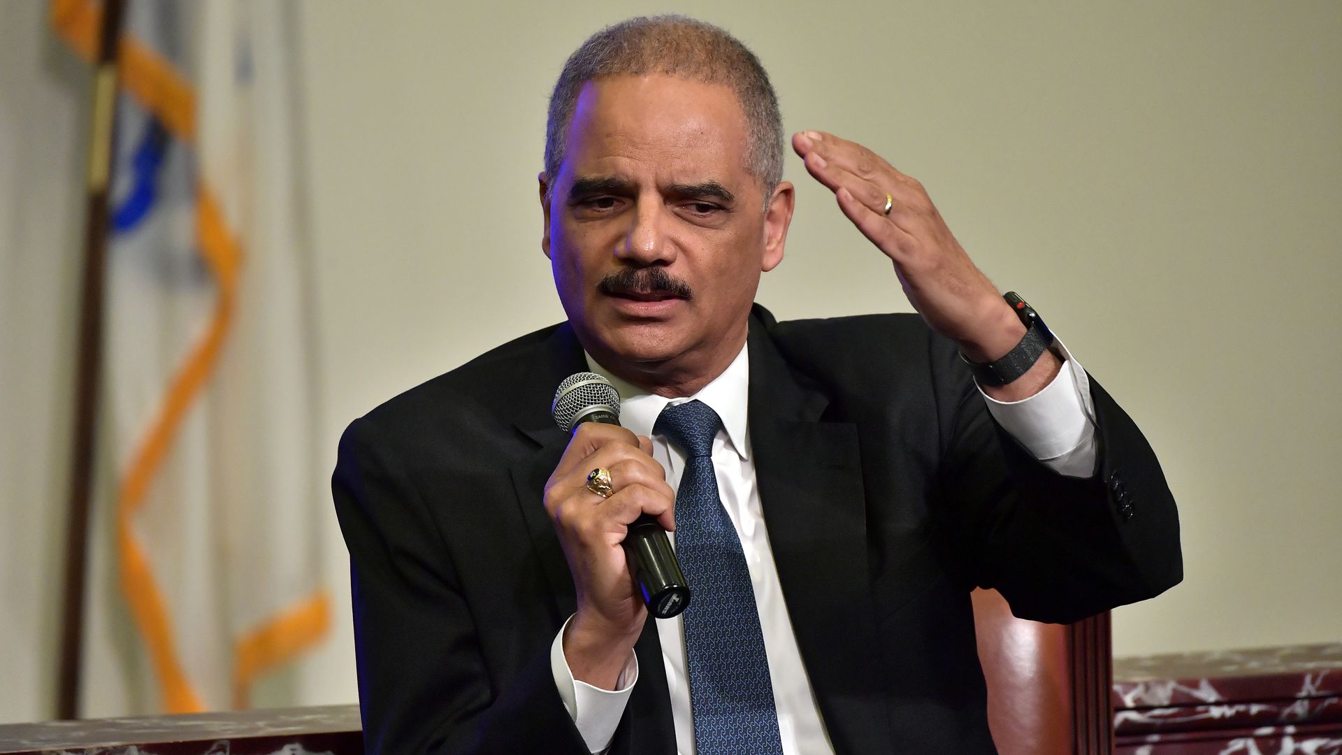 Eric Holder gestures with one arm.