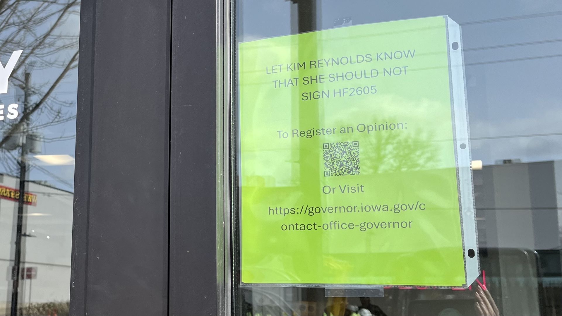 A flyer outside despensary with a qr code to voice an opinion