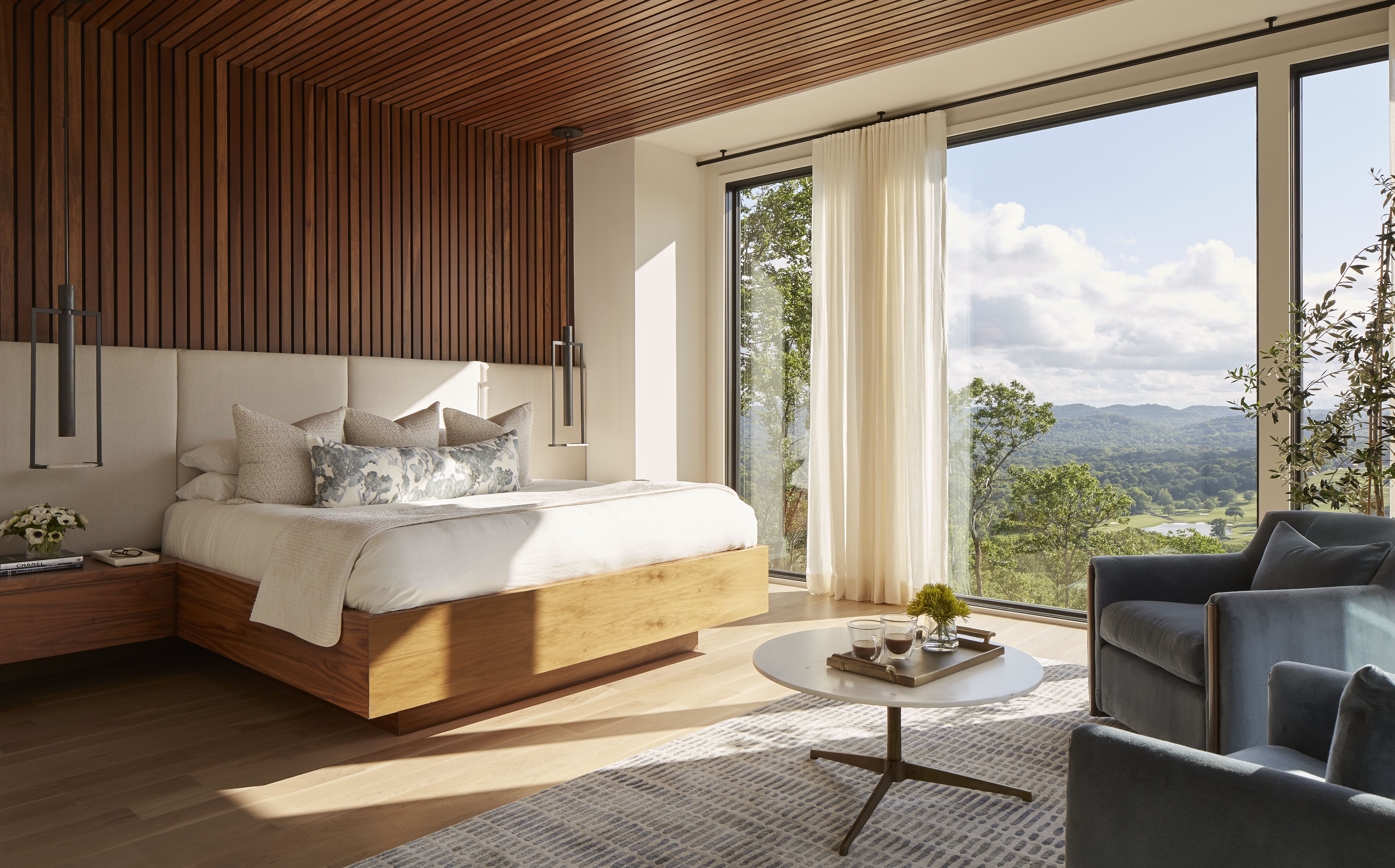 bedroom with a glass wall and mountain view