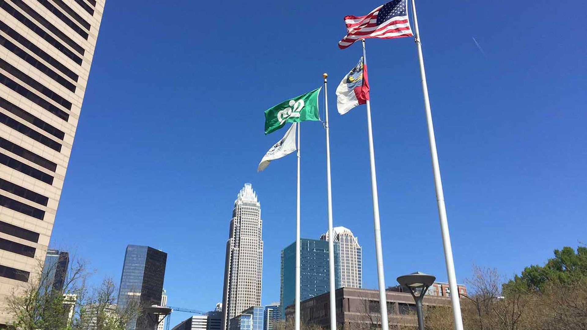 flagpoles outside the Charlotte-Mecklenburg Government center with the American flag, NC flag, and Charlotte flag.