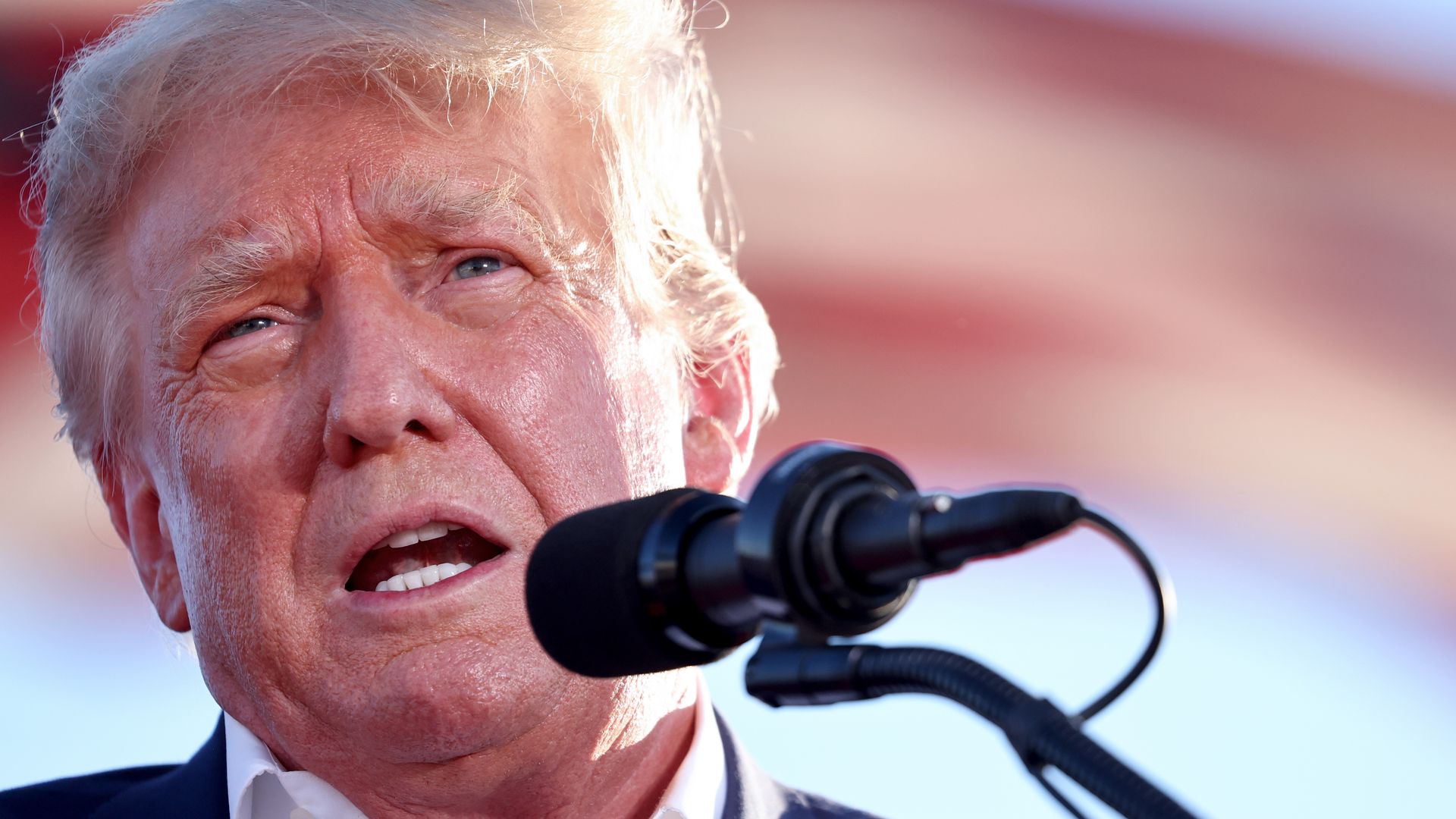 Photo of Donald Trump speaking into a mic at a rally