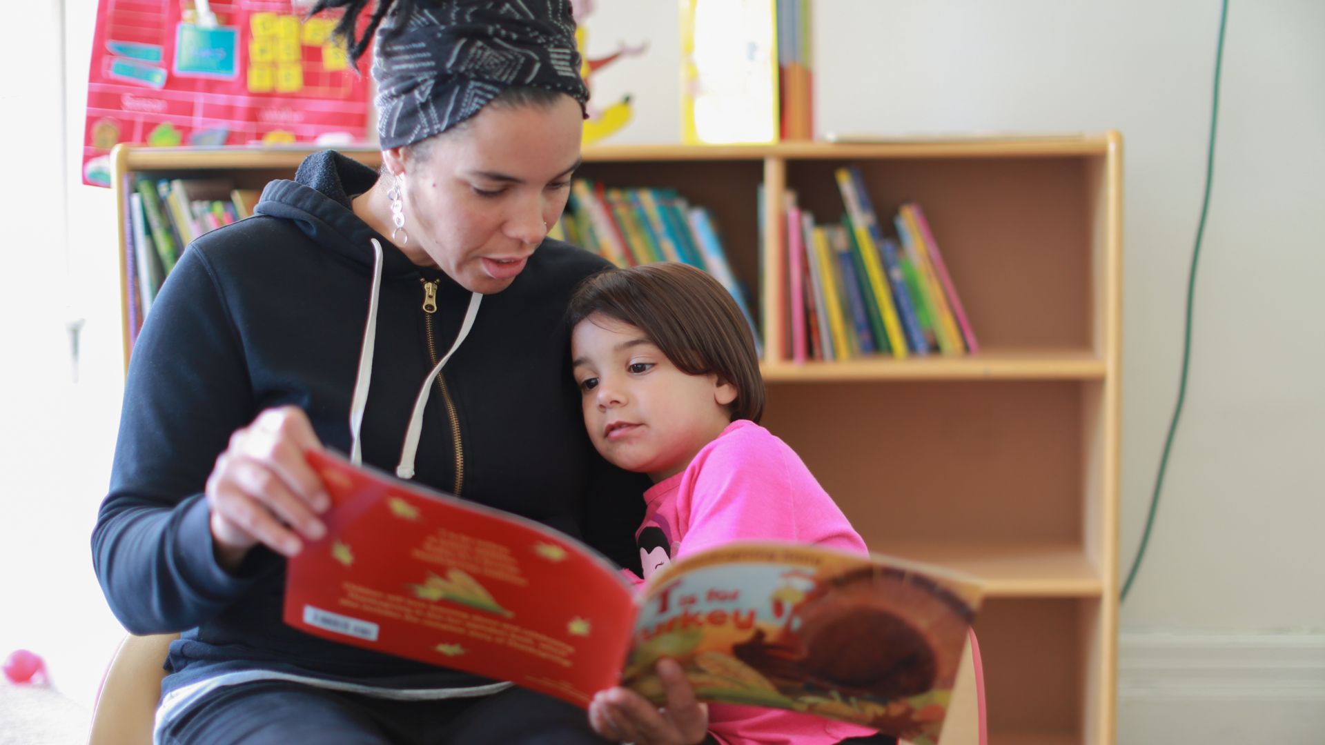 adult volunteer reads child a book