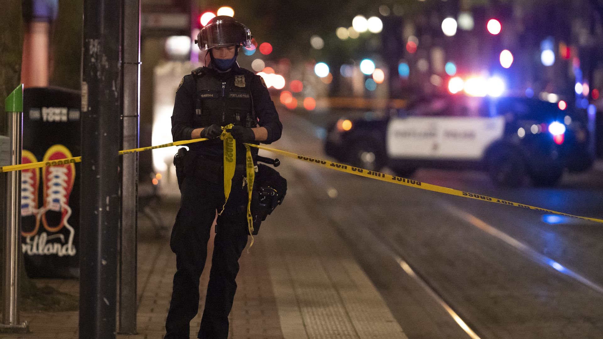 A Portland police officer ties a police line around the scene of a fatal shooting near a pro-Trump rally on August 29, 2020 in Portland, Oregon.
