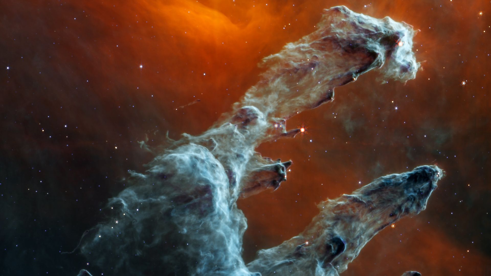 Pillars of Creation in blue and red seen by the JWST