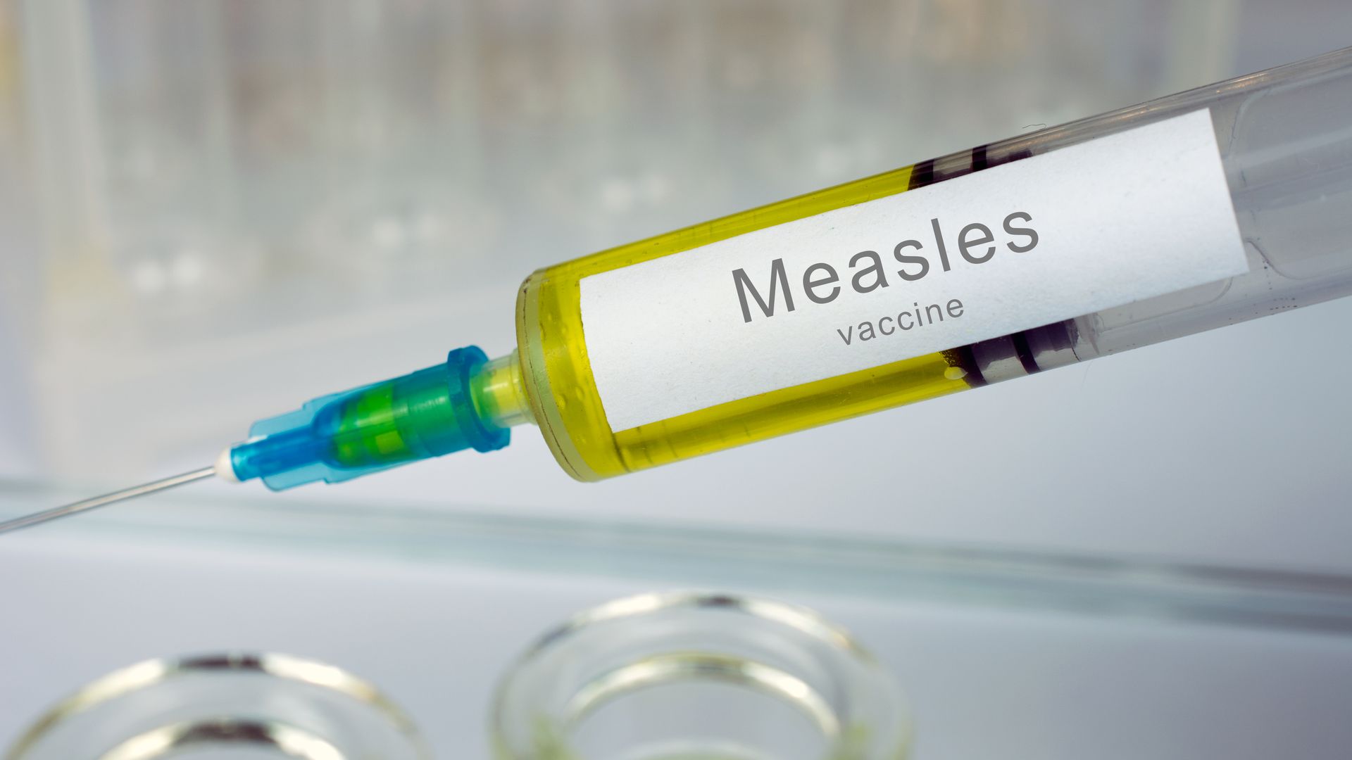 Hands of doctor or nurse in medical gloves with medical syringe ready for injection a shot of Measles vaccine. close up, selective focus