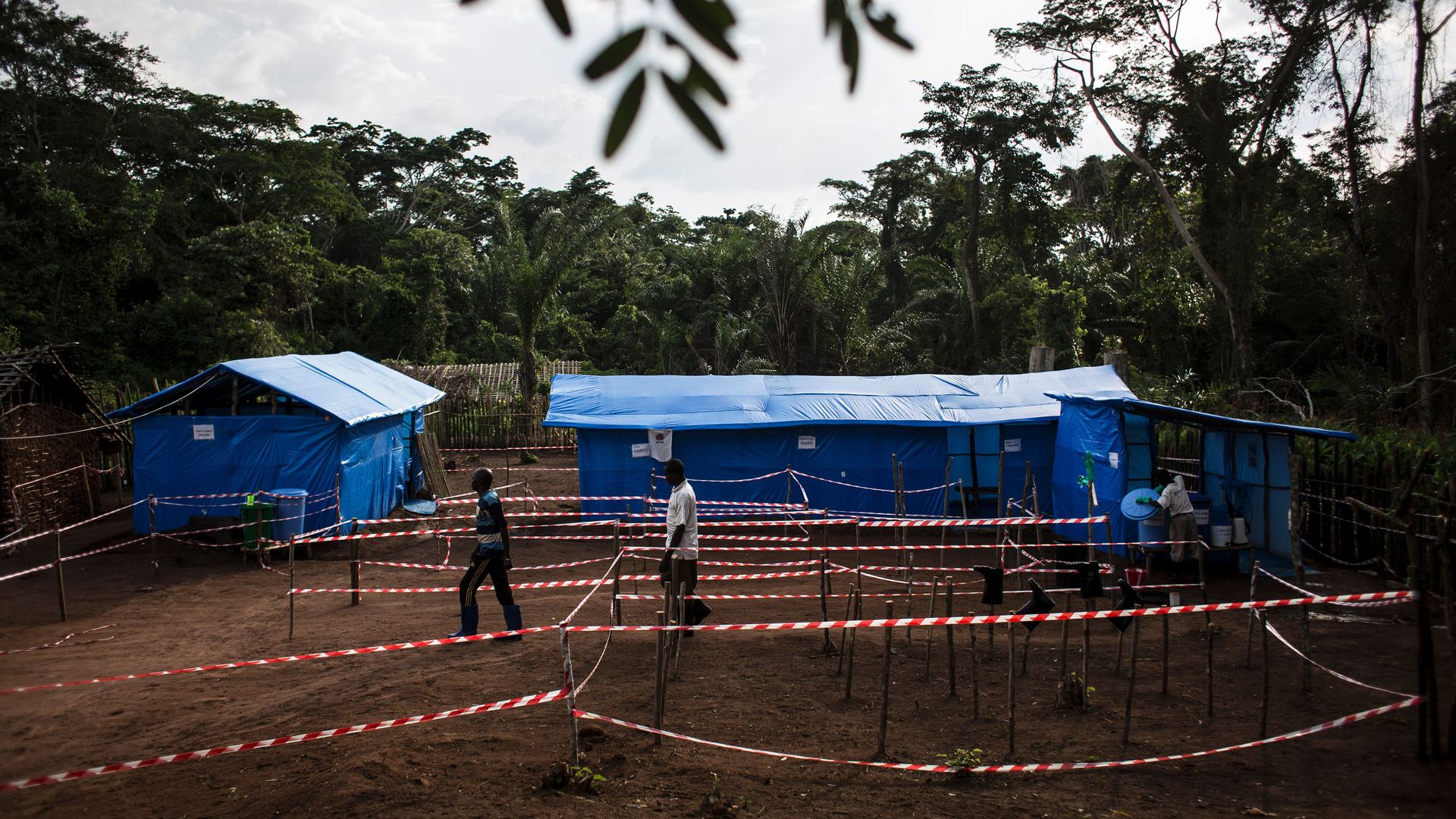 Health workers walk at an Ebola quarantine unit on June 13, 2017 in Muma, after a case of Ebola was confirmed in the village
