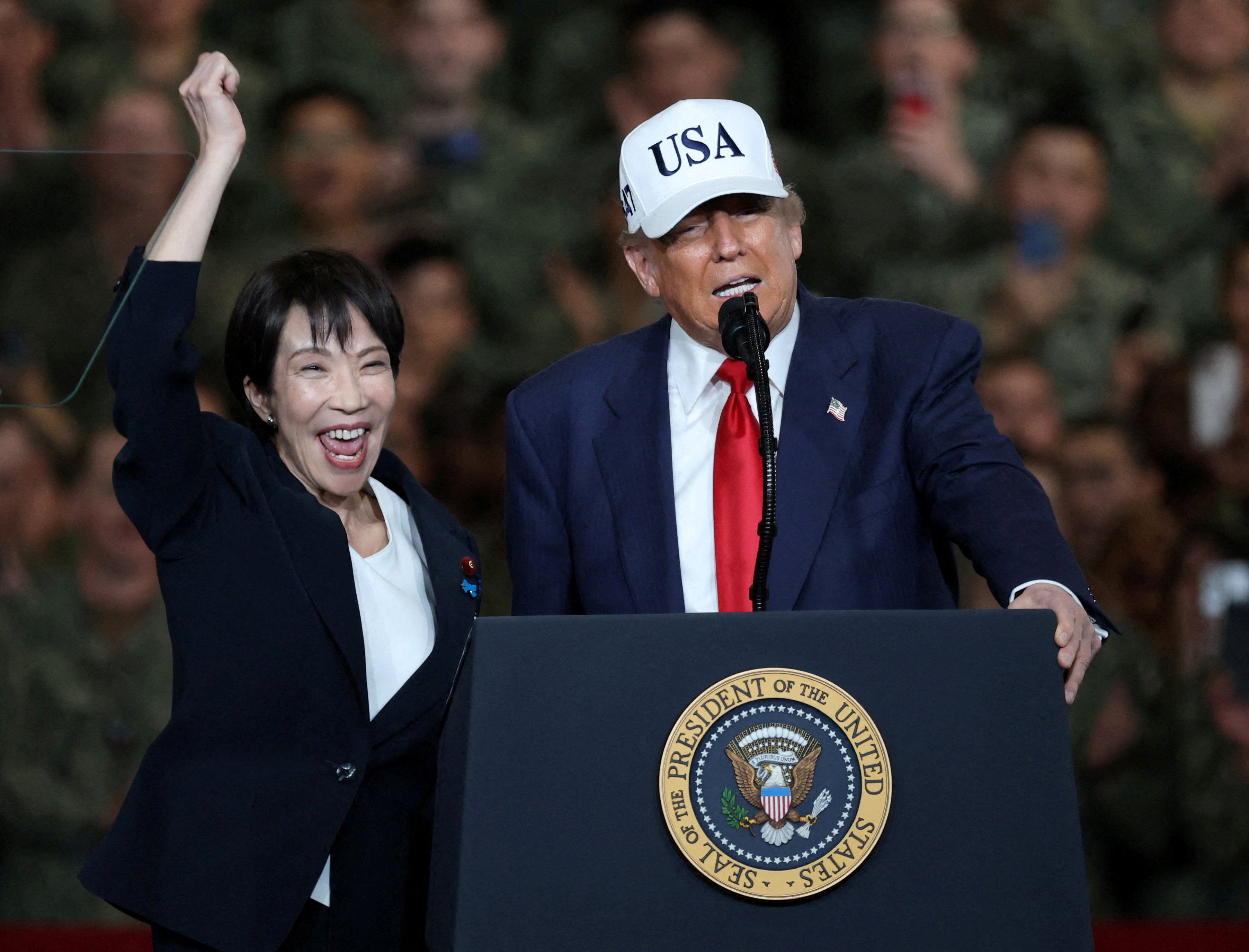 Japanese Prime Minister Sanae Takaichi cheers as President Trump speaks to military personnel aboard the aircraft carrier USS George Washington today in Yokosuka, Japan.