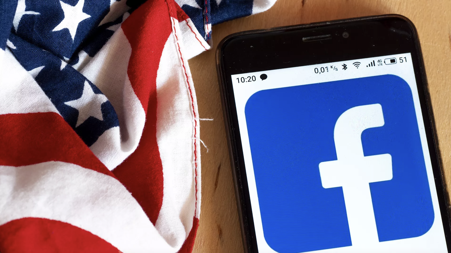 An illustration of the Facebook logo on a smartphone next to an American flag.
