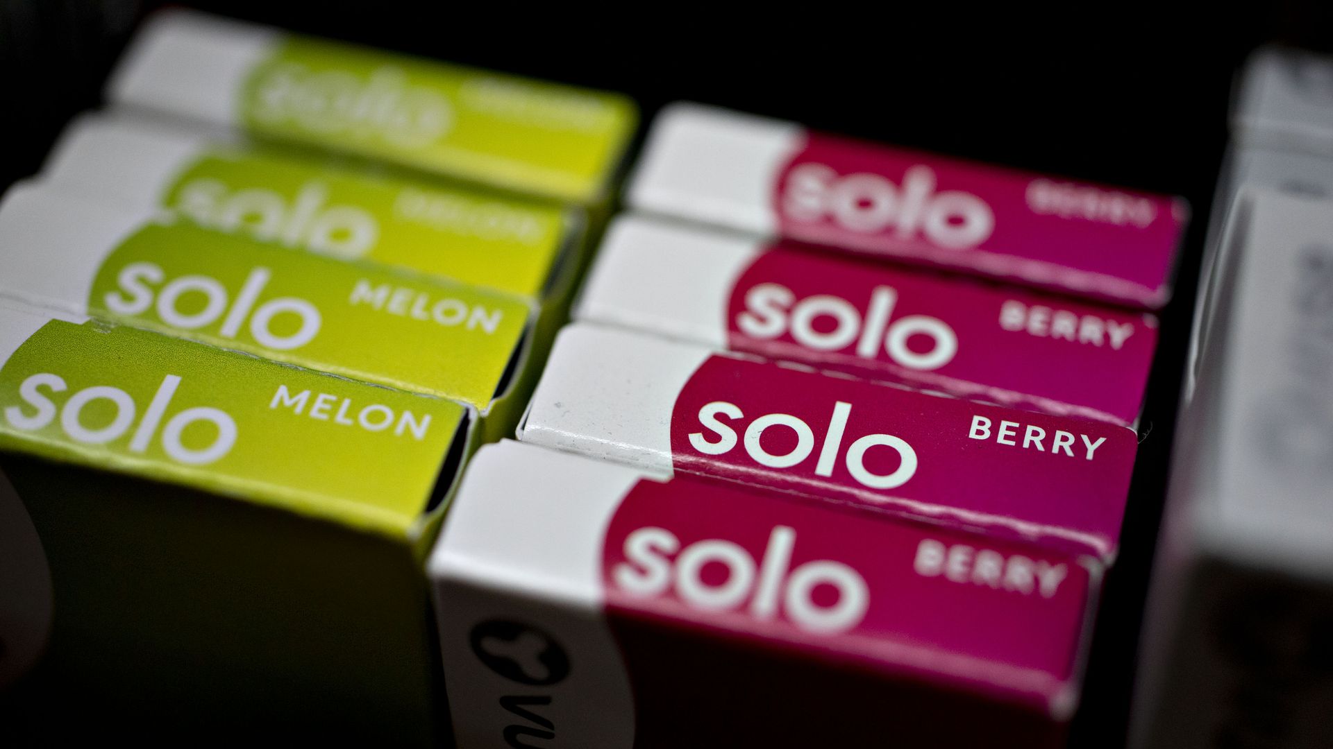 green and pink colored flavored nicotine cartridges read Melon and berry on a store shelf. 