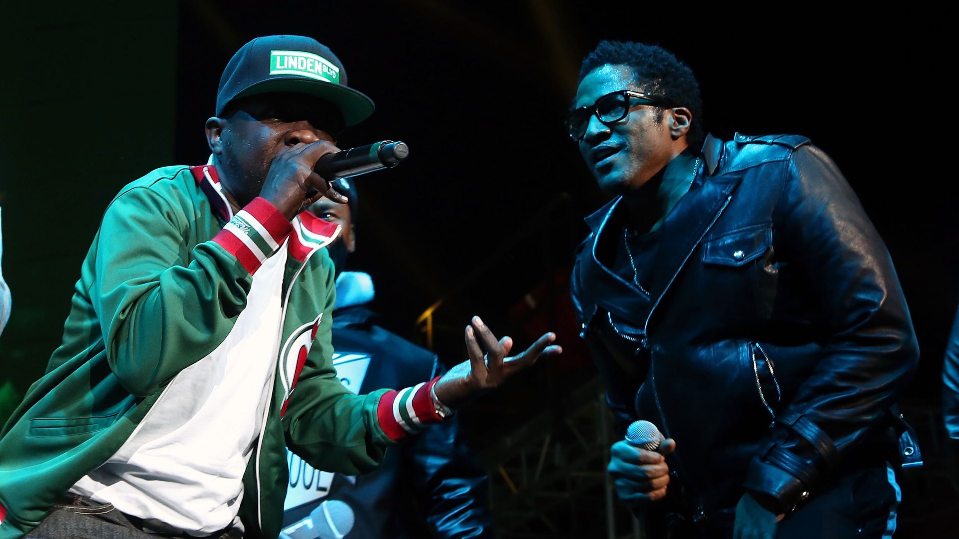 Phife Dawg and Q-Tip perform on stage. 