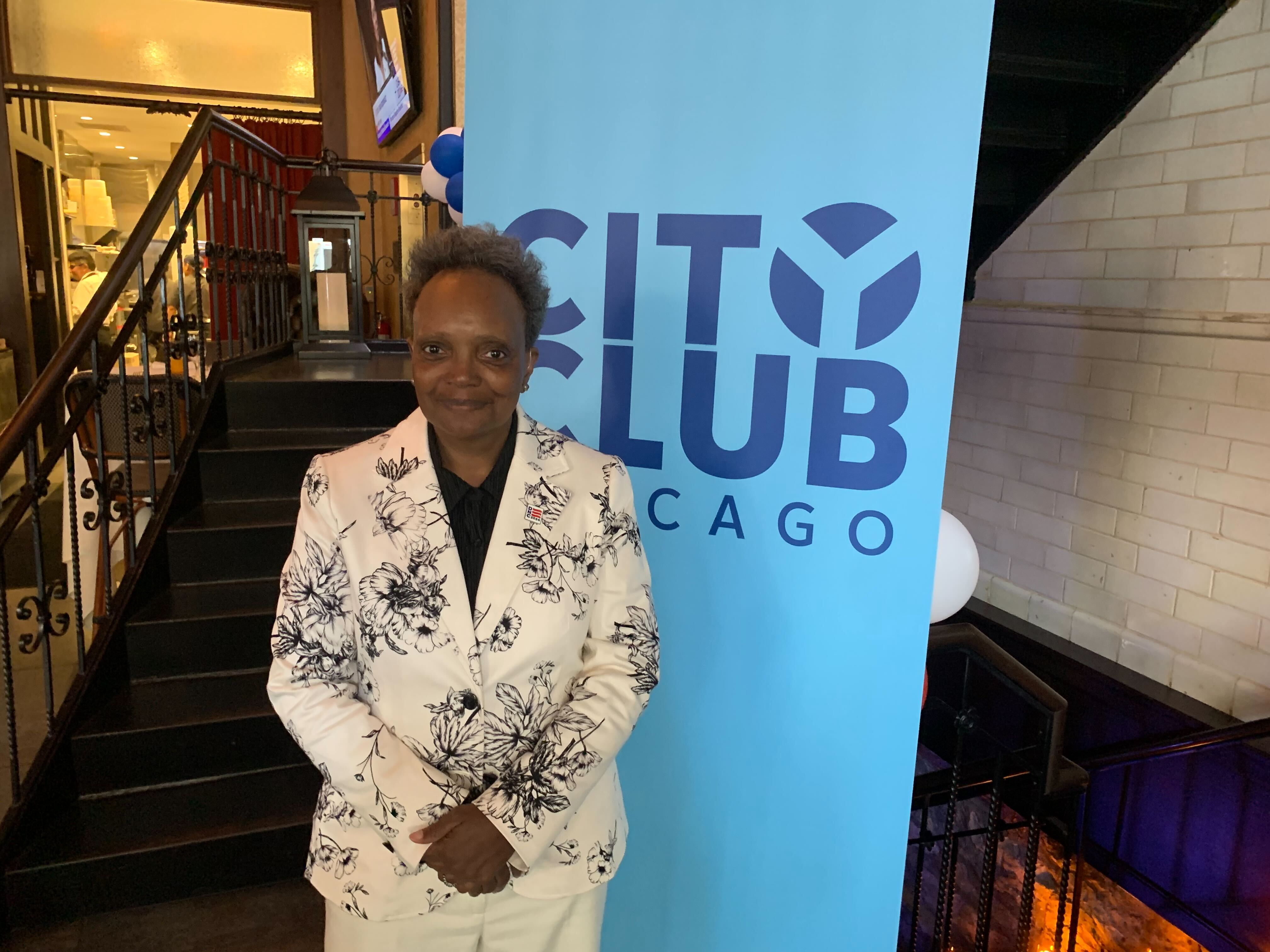 Photo of a woman standing in front of a sign that says "City Club Chicago" 