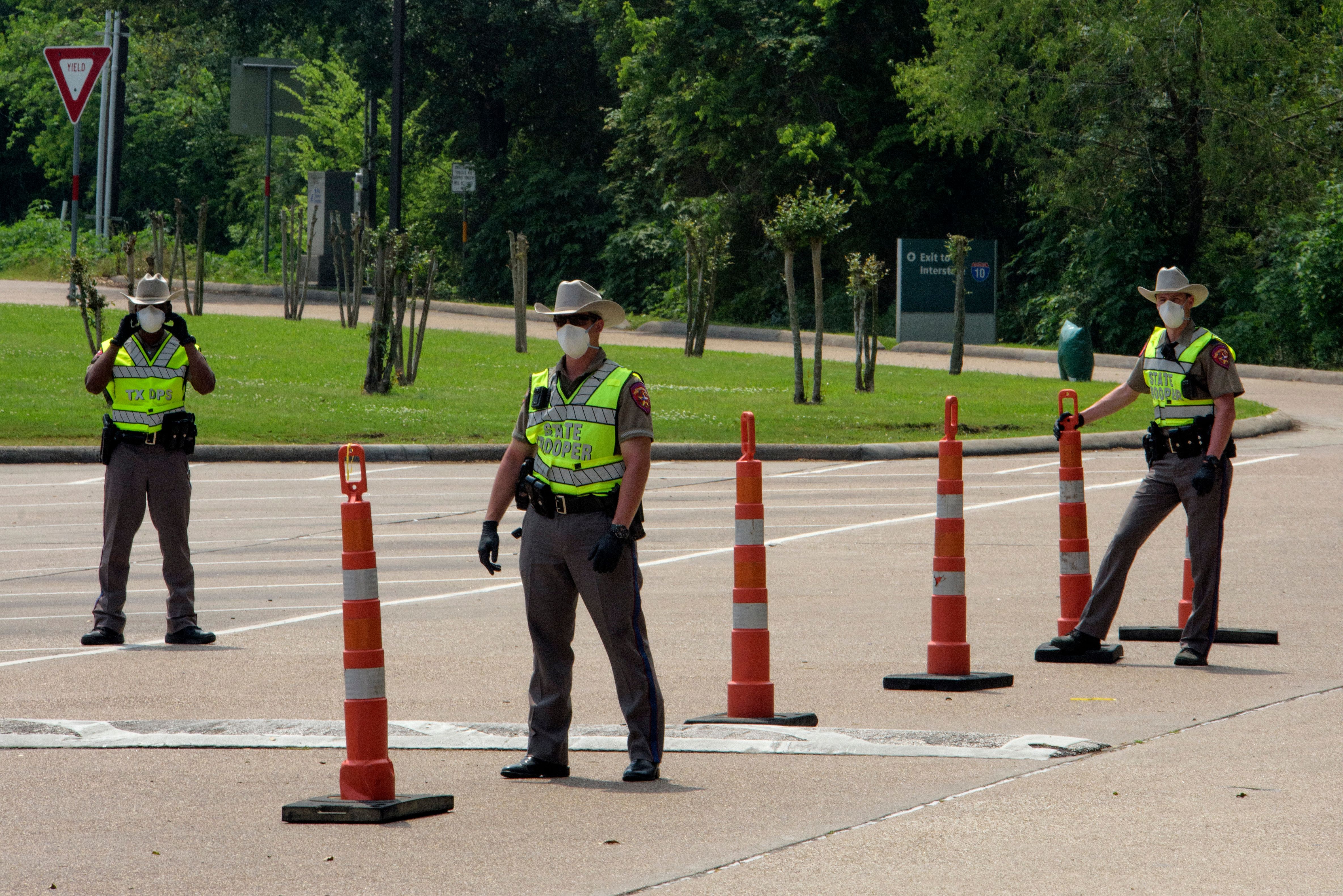 Texas State Troopers wait for drivers to arrive at a check point at the Texas Travel Information Center 