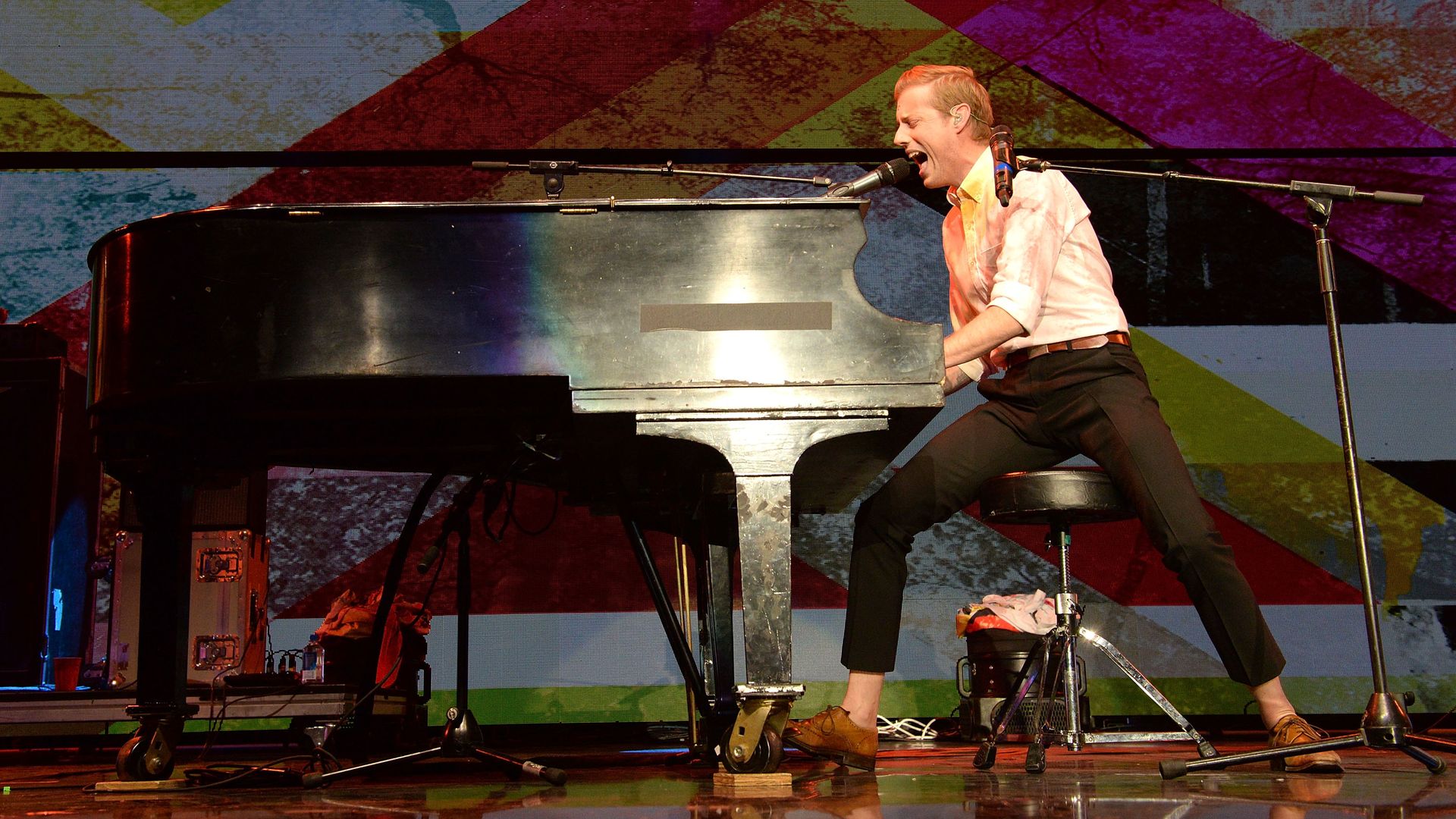 Andrew McMahon performs on stage at a piano. 